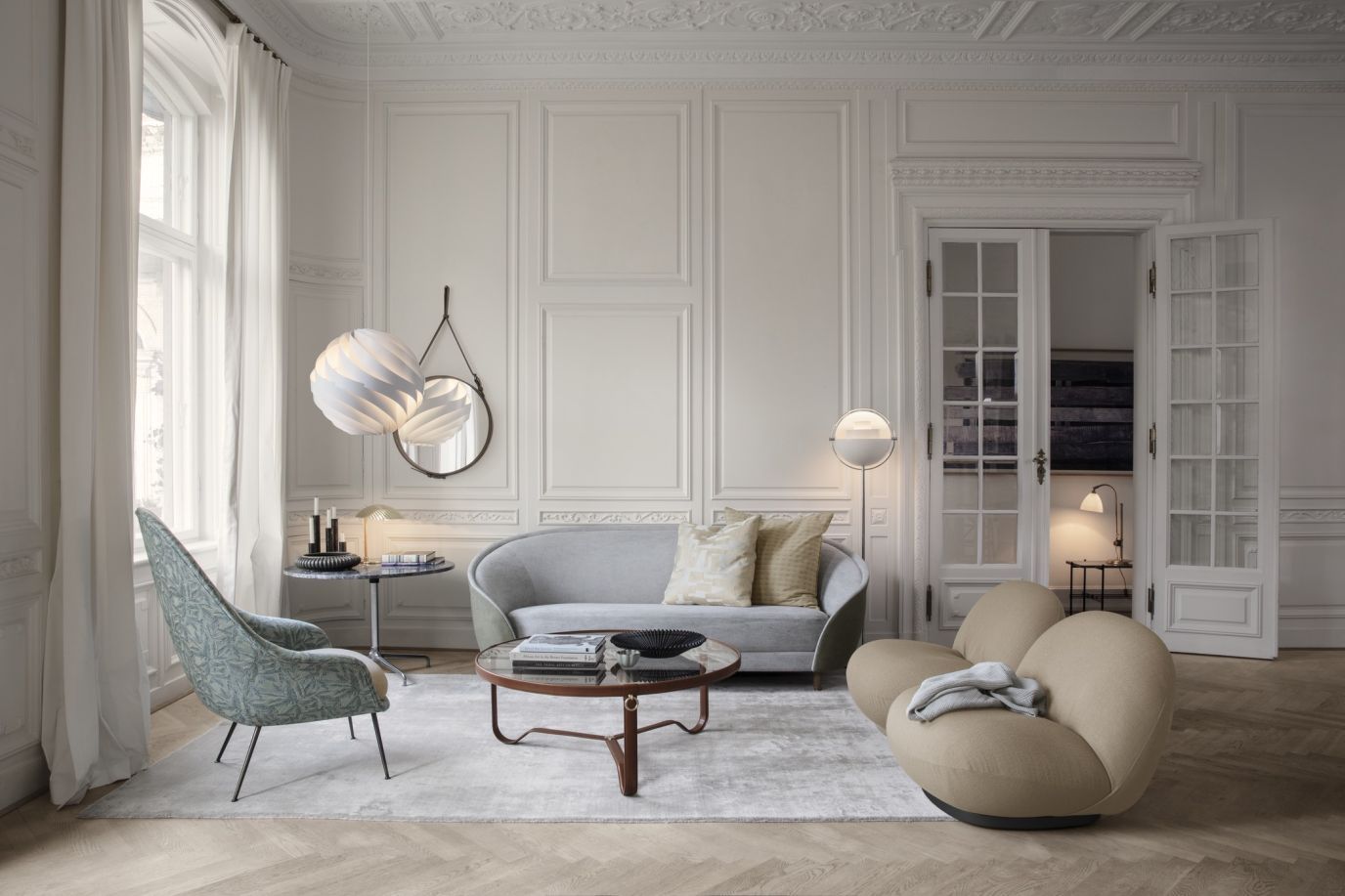 Helle Wohnzimmer-Szene mit Gubi Stehleuchte, Design-Möbeln und stilvoller Beleuchtung.