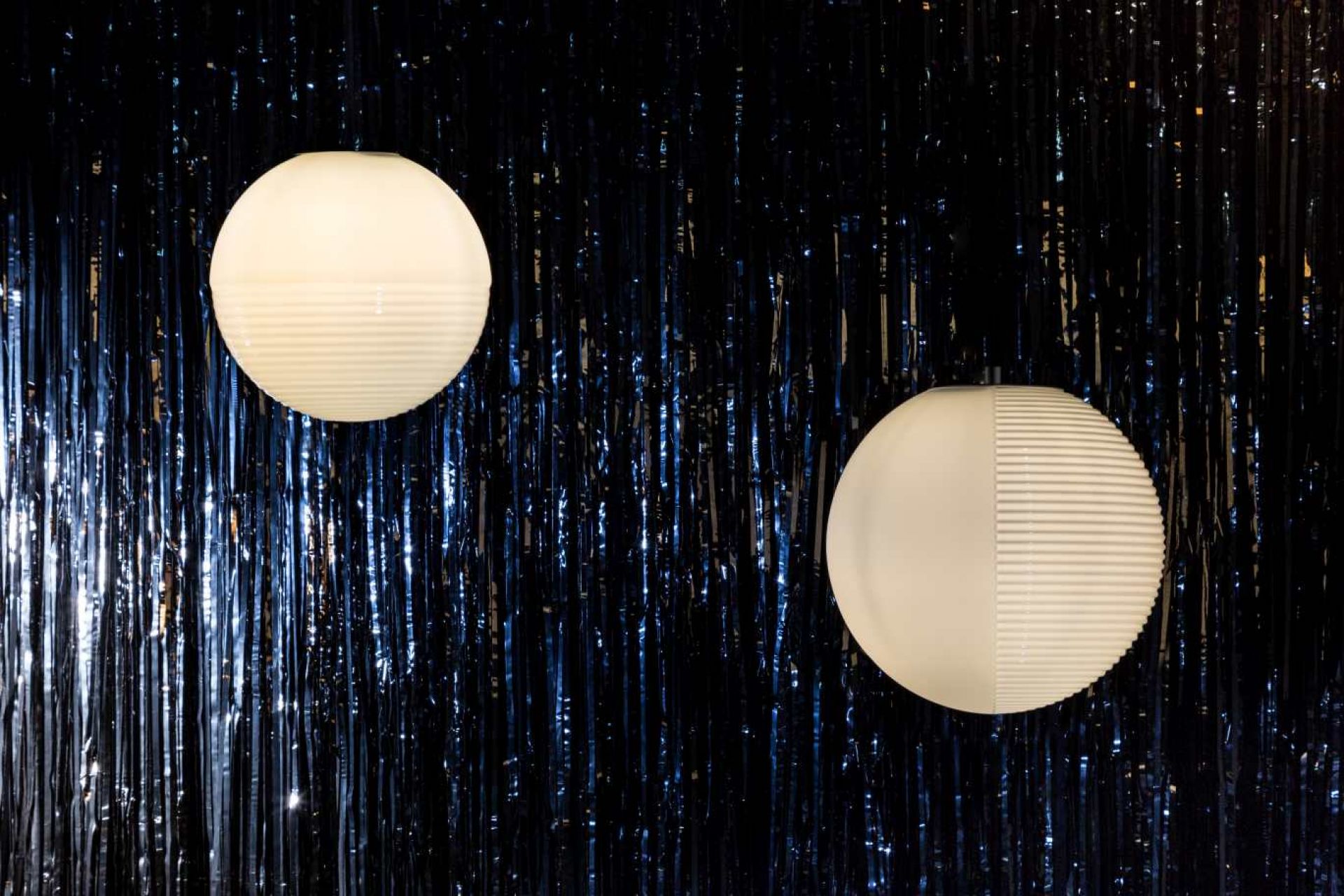 Zwei Stellar Pendelleuchten in Weiß vor einem glänzenden, dunklen Hintergrund. Moderne Innenbeleuchtung.