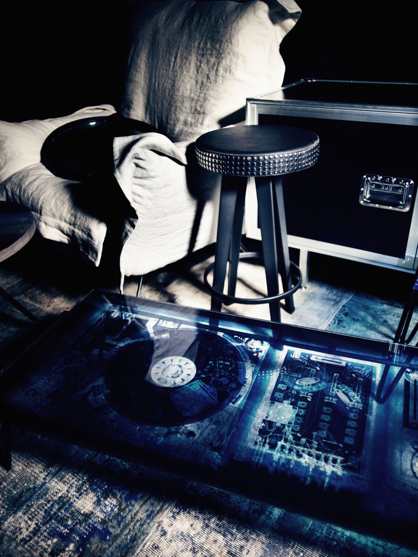 Total Sideboard von Moroso Diesel mit Glasplatte, Barhocker und Kissen in dunkler, stimmungsvoller Atmosphäre.