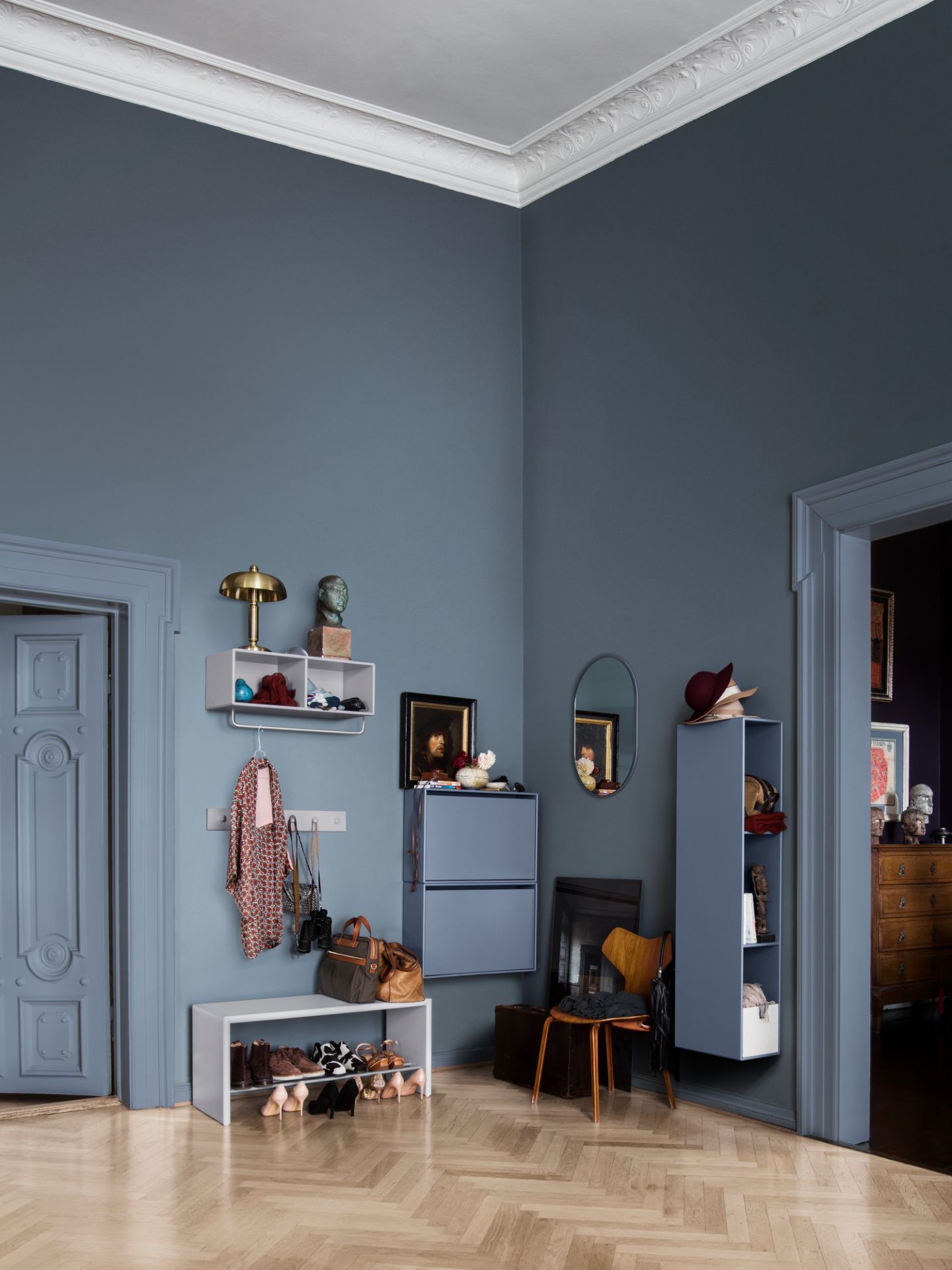 Heller Flur mit weißer Schuhbank Montana, Schuhen, Garderobe und blauen Regalen.