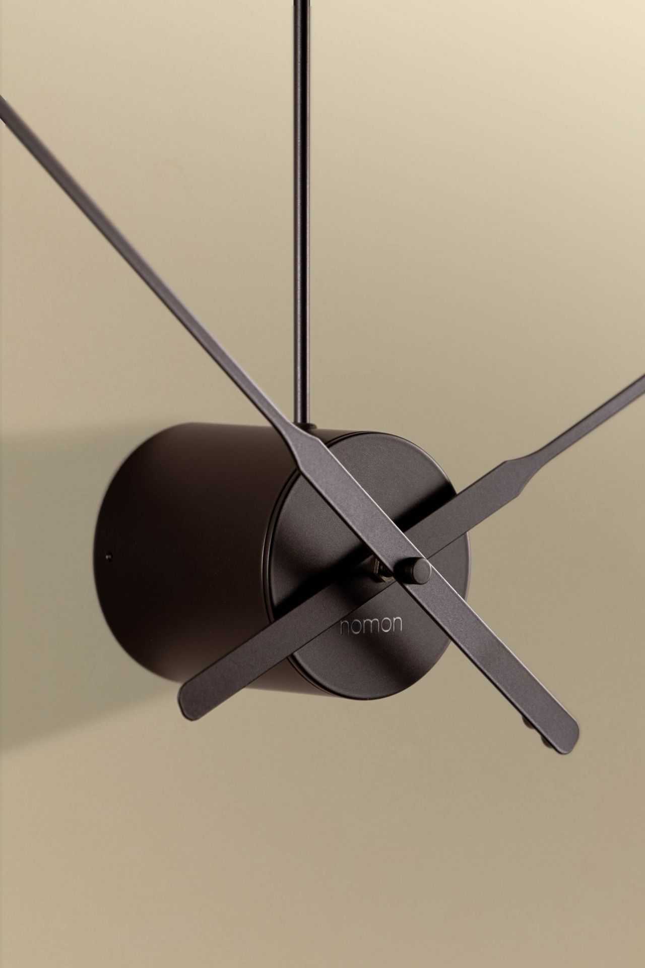 Nahaufnahme der modernen Nomon Ombra Wanduhr in Dunkelgrau mit minimalistischem Design.