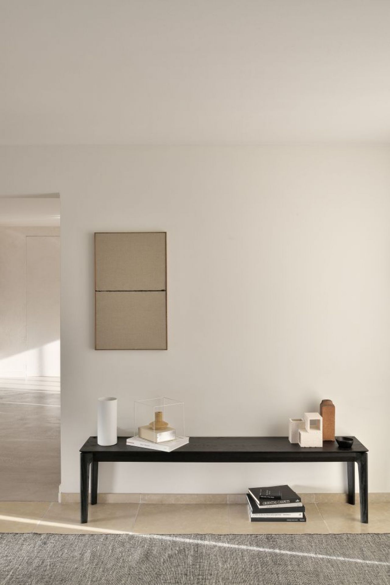 Schwarze Bok Bank aus Eiche von Ethnicraft im minimalistischen Interieur mit Deko-Objekten und Büchern.