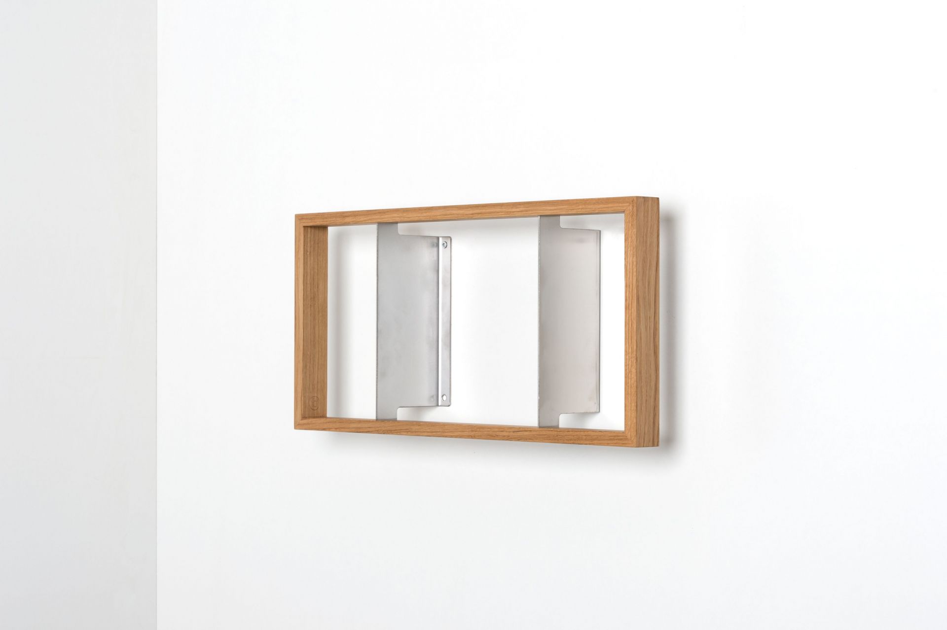 Regal b5 Eiche: Wandregal aus Eichenholz mit zwei silbernen Halterungen an einer weißen Wand.