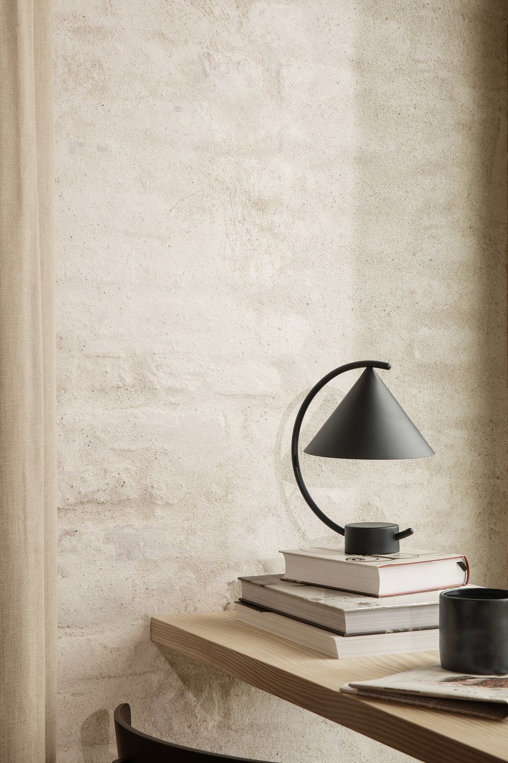 Meridian Lampe von Ferm Living in Cashmere auf Büchern, moderne Tischleuchte.
