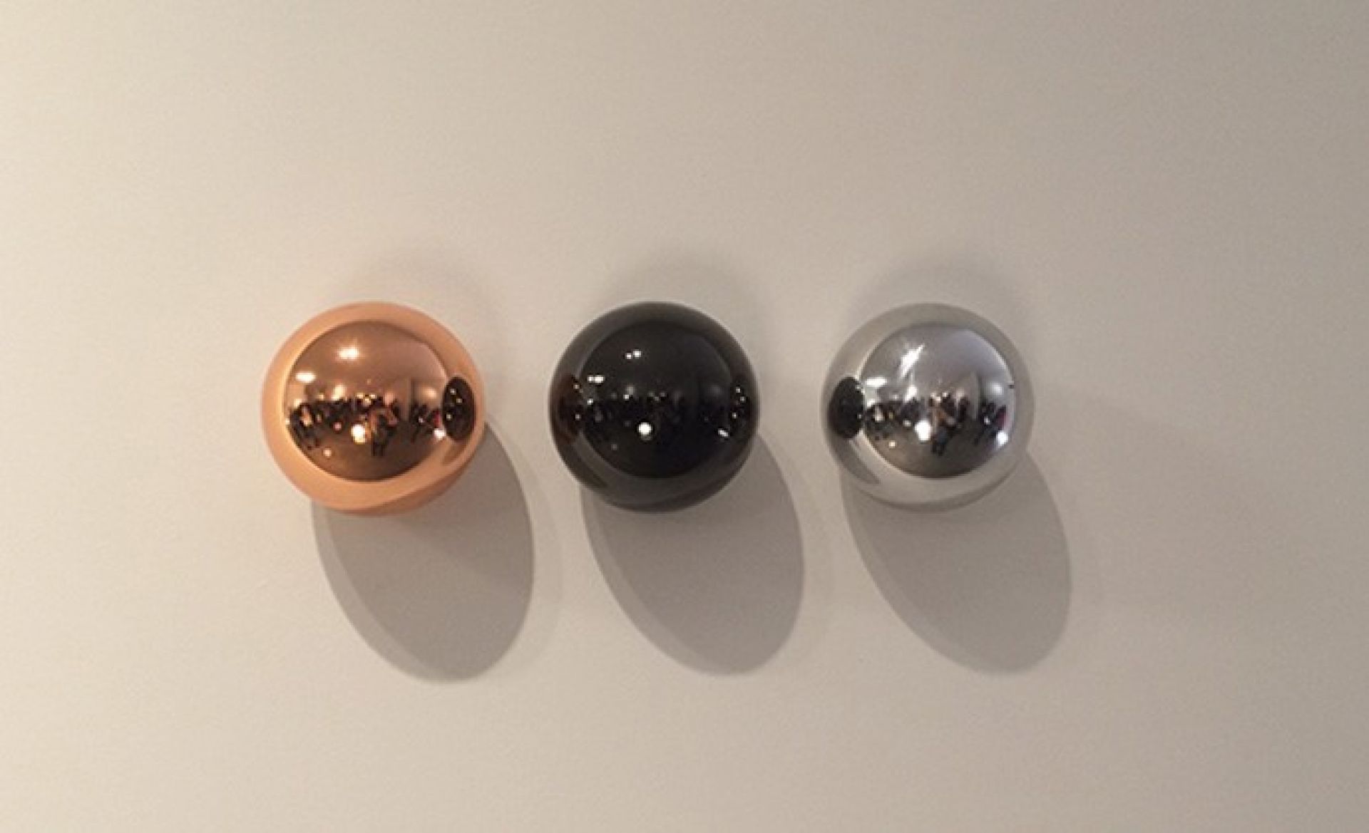 Drei Kugeln in Kupfer, Schwarz und Silber der Copycat Leuchte von Flos.