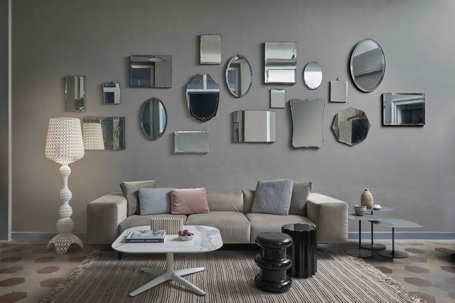 Wohnzimmer mit Kabuki Stehleuchte von Kartell, Sofa, Couchtisch und Spiegeln an der Wand.