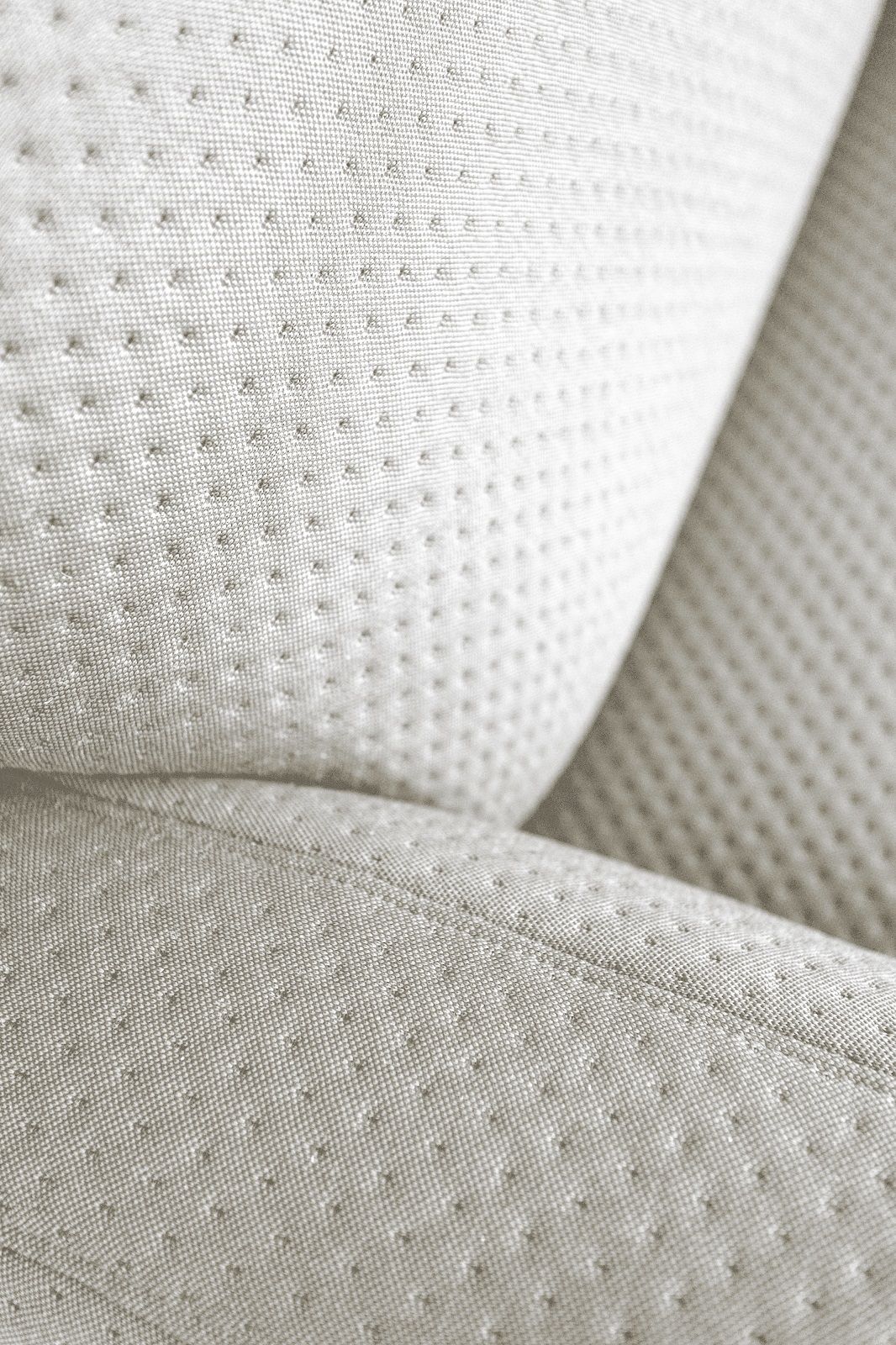 Detailaufnahme des hellen, strukturierten Stoffbezugs vom Hartô Auguste Sofa. Hochwertige Polsterung mit feinen Nähten.