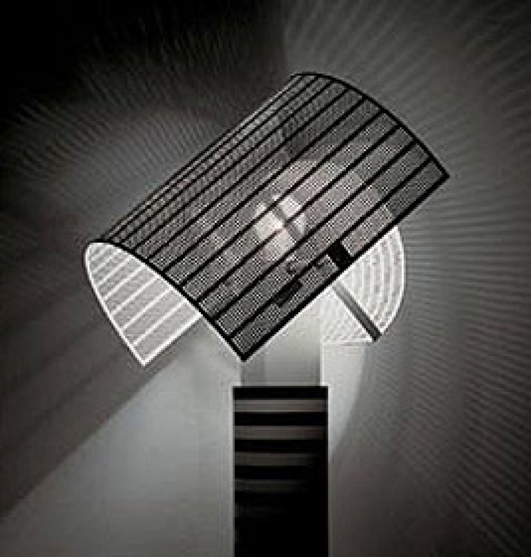 Shogun Tischleuchte von Artemide: Design-Lampe mit schwarzem, perforiertem Schirm und hellem Lichtschein.