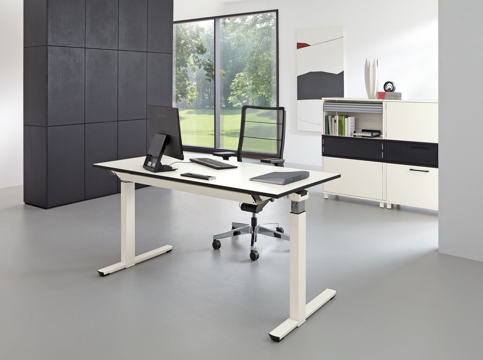Heller Raum mit Palmberg Crew Schreibtisch, höhenverstellbar, in Weiß mit Büromaterial und Büromöbeln.