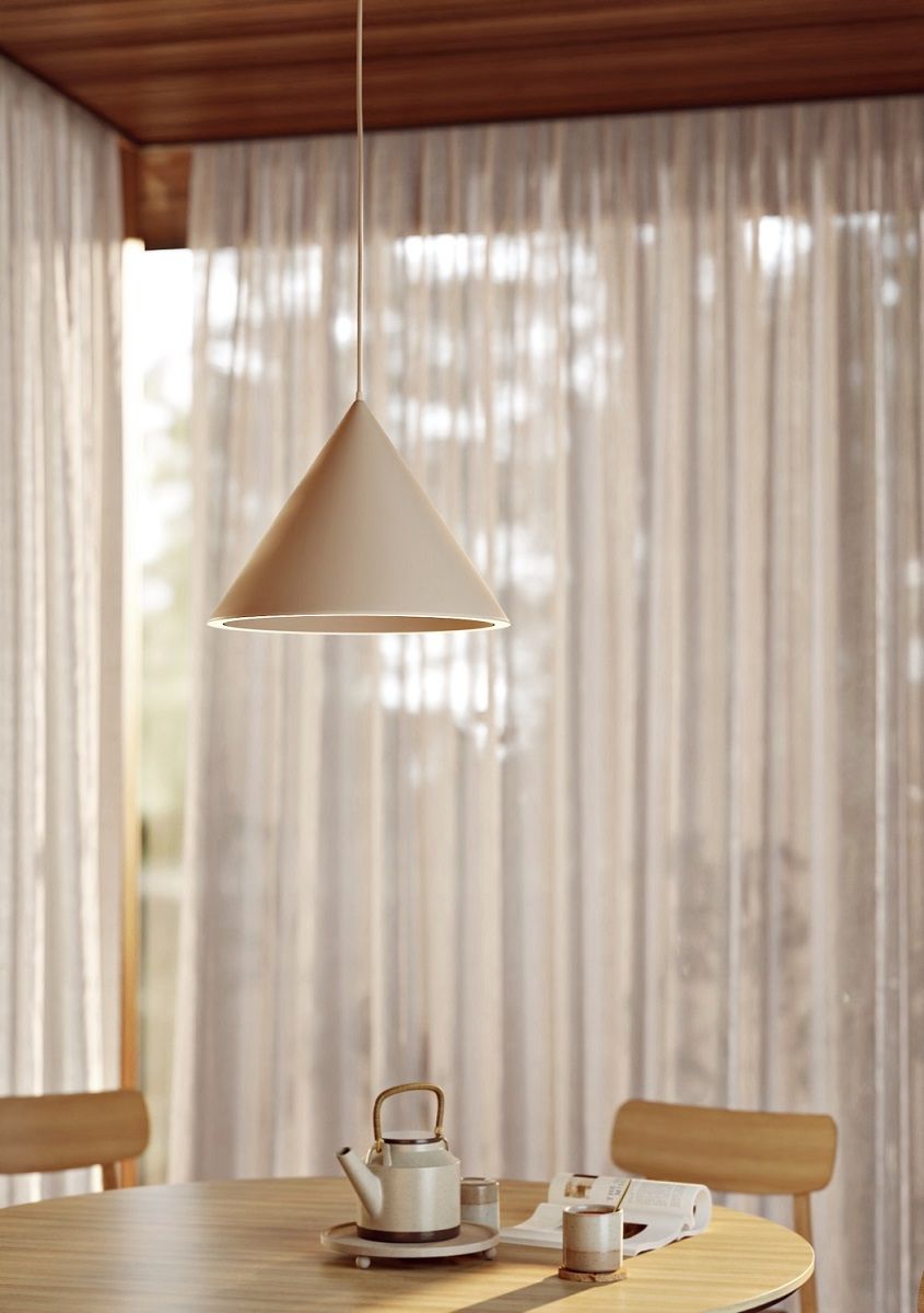 Beige Annular Pendelleuchte von Woud über Esstisch mit Teekanne und Vorhängen im Hintergrund.