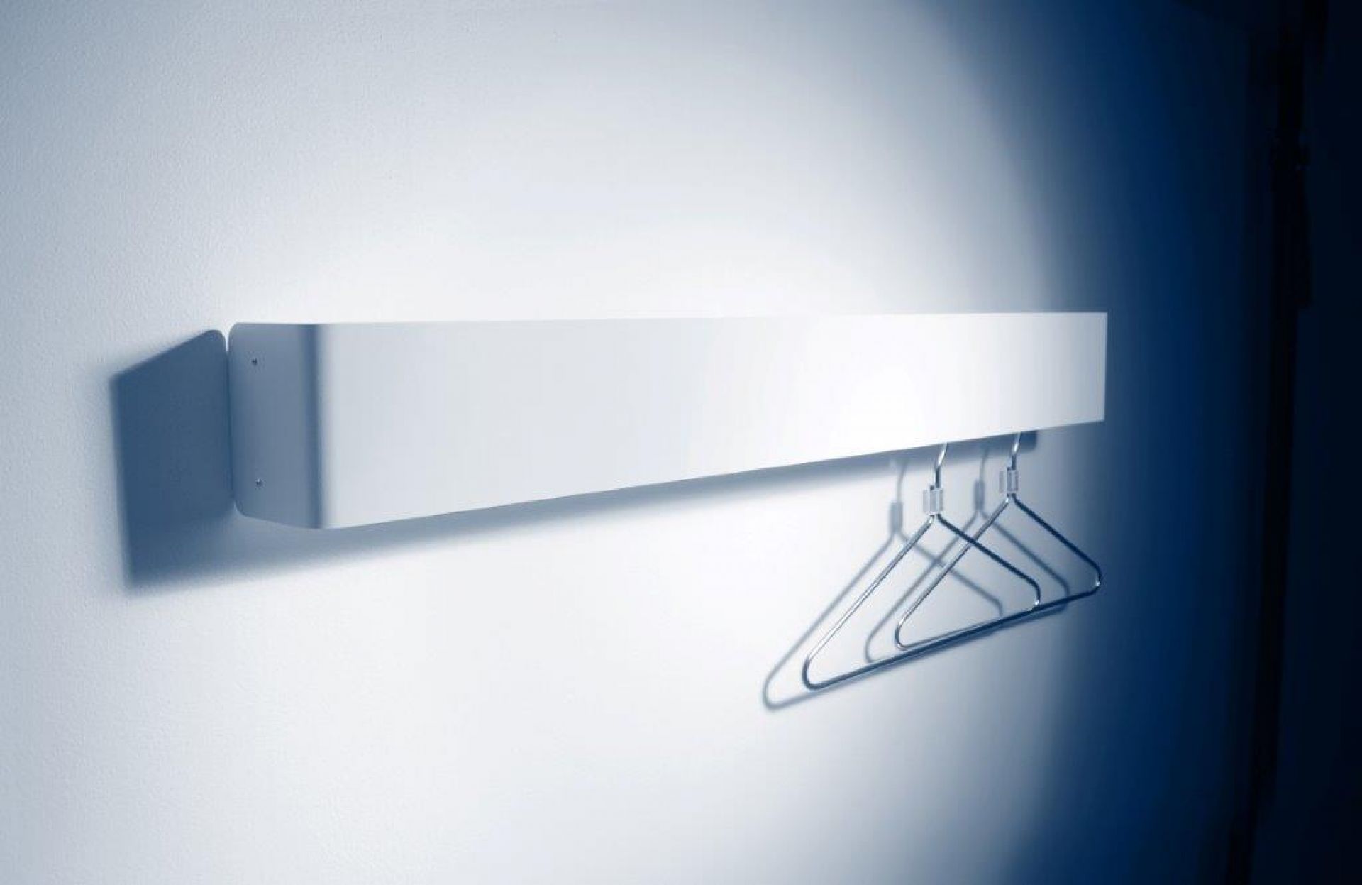 Weiße Radius Garderobe an der Wand mit zwei Kleiderbügeln, moderne Wandgarderobe für Flur und Eingangsbereich.