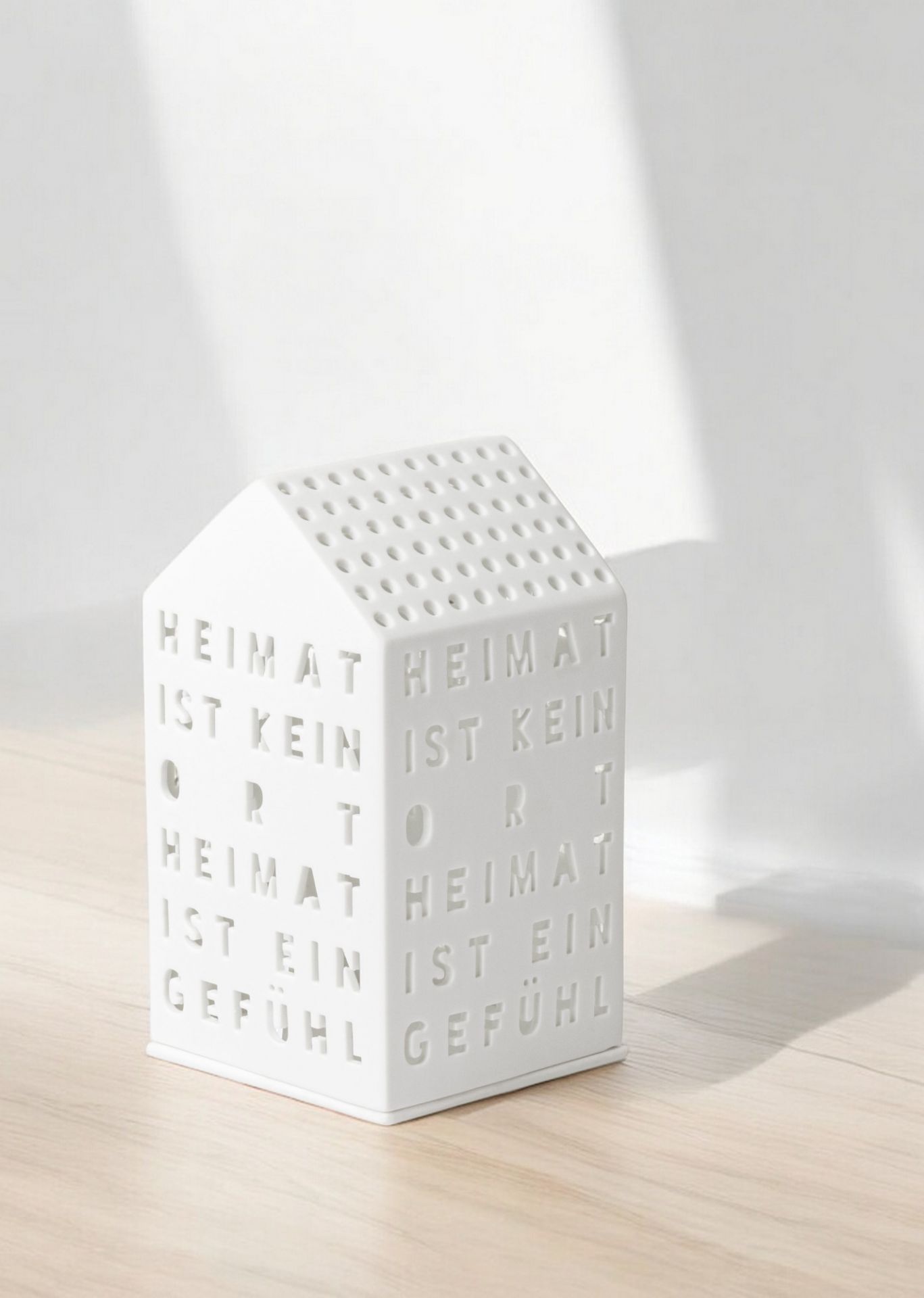 Weißes Lichthaus "Heimat ist kein Ort" von Räder, stimmungsvolle Dekoration für Zuhause.