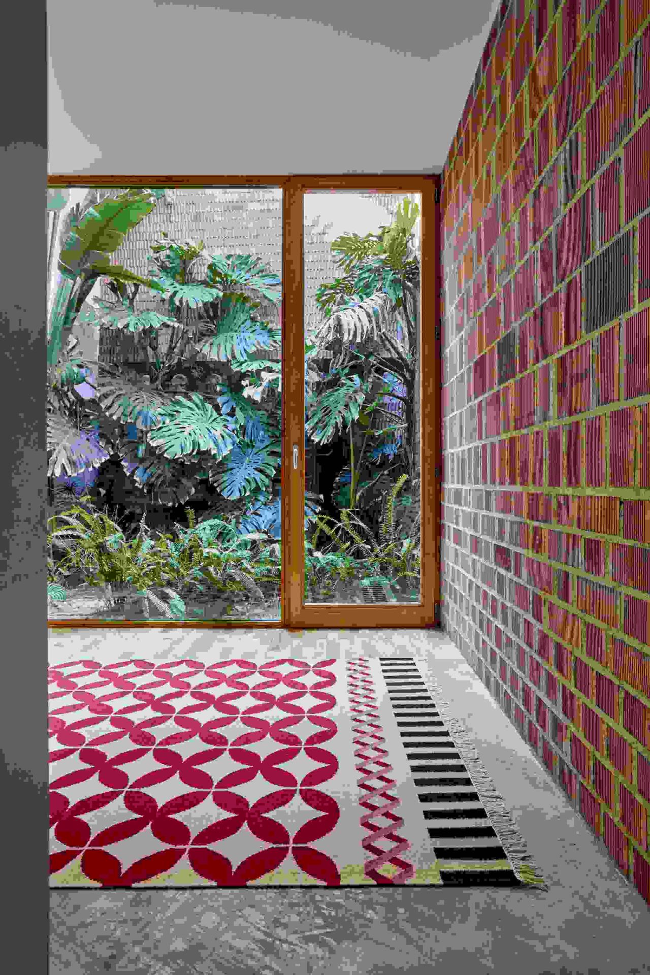 Kilim Catania Teppich mit rotem Blütenmuster und schwarzen Streifen in modernem Raum.