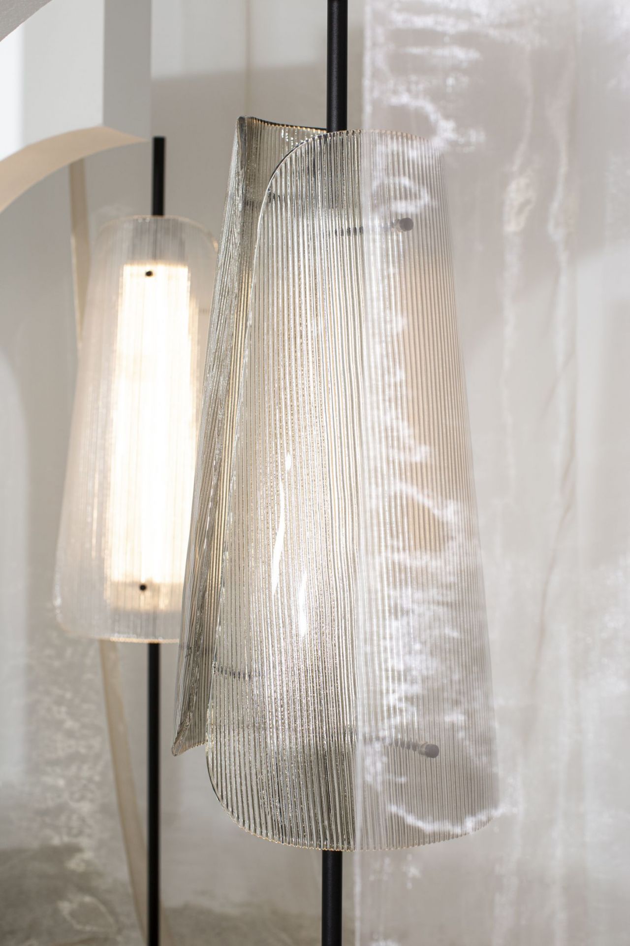 Nahaufnahme der Bent Two Stehleuchte mit rauchgrauen, geriffelten Glasschirmen und schwarzem Gestell.