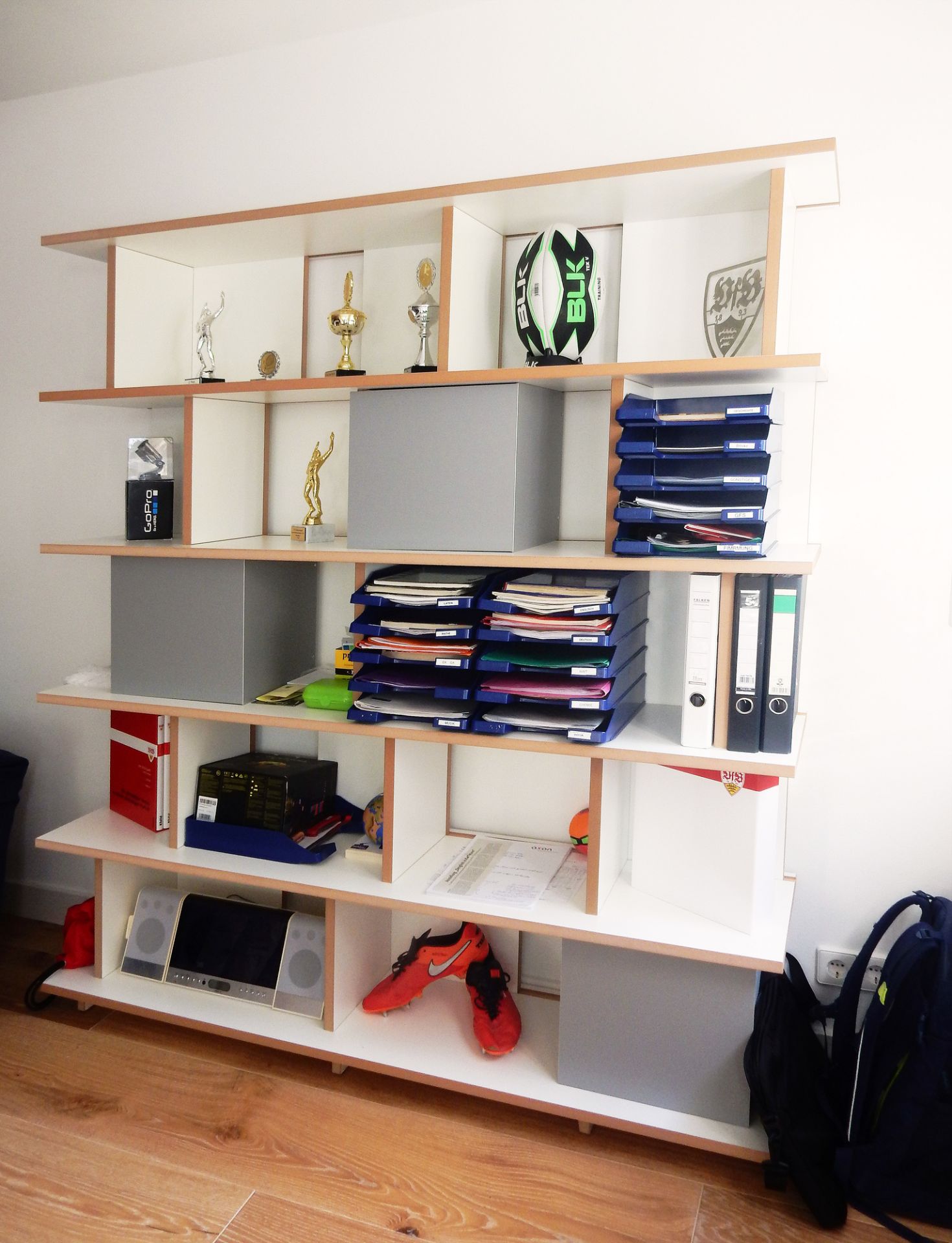 Vollständig bestücktes Tojo Stell Regal mit Fächern, Ordnern, Deko und persönlichen Gegenständen.