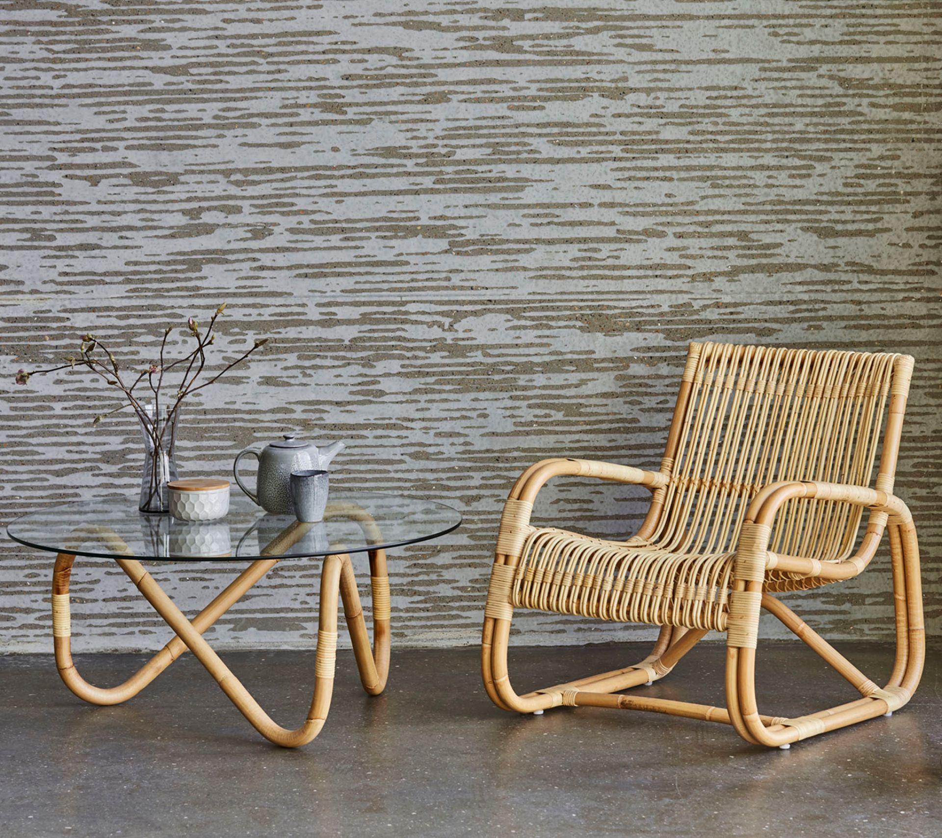 Cane-Line Curve Loungesessel Indoor aus Rattan mit passendem Couchtisch und Teegeschirr.