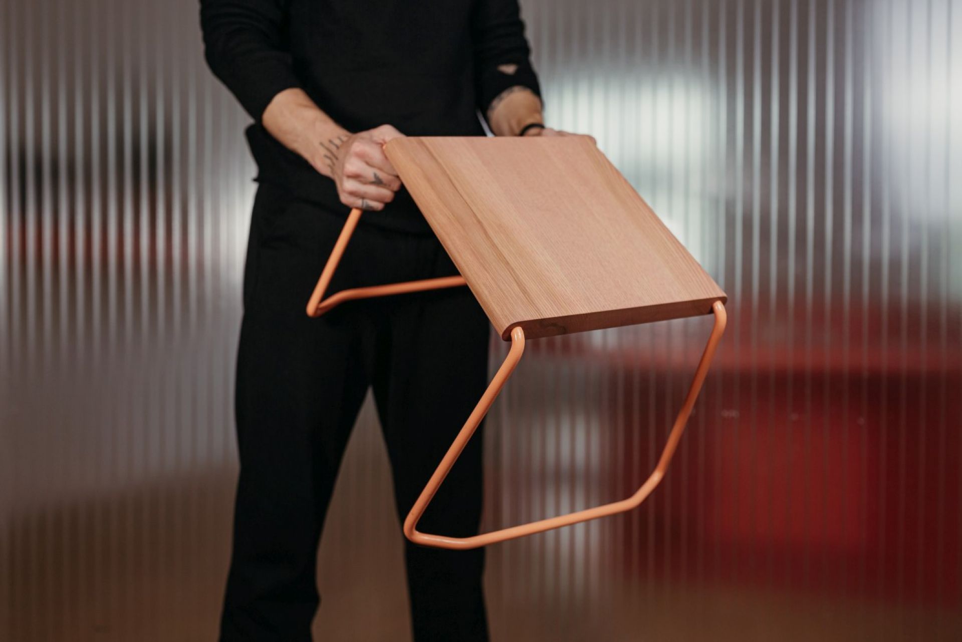 Mann hält D:002 Beistelltisch Ultraviolett von Fuchs & Habicht. Moderner, minimalistischer Nachttisch.