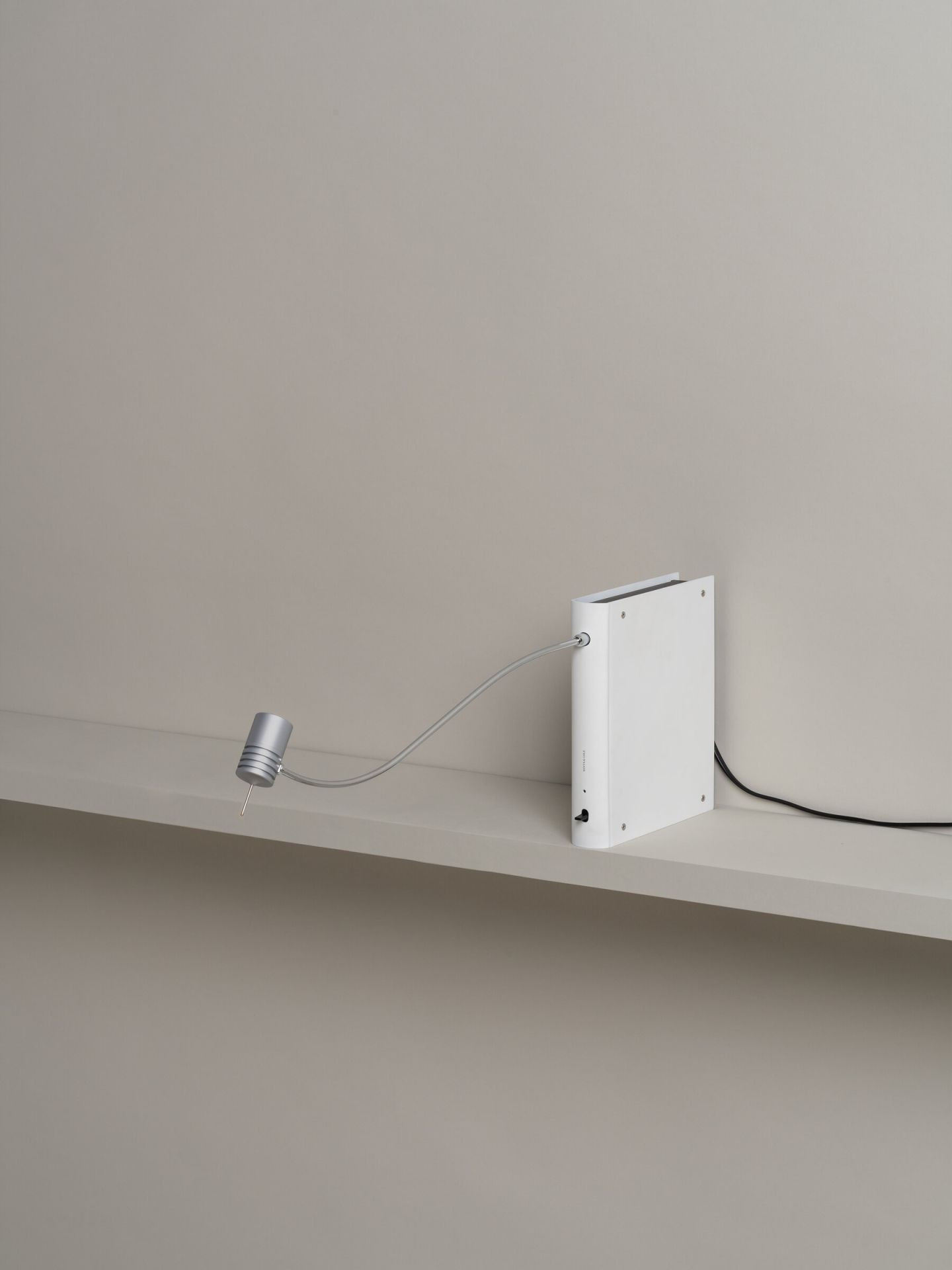 Bib Luz Tischleuchte von Santa & Cole in Off White auf einem Regal.