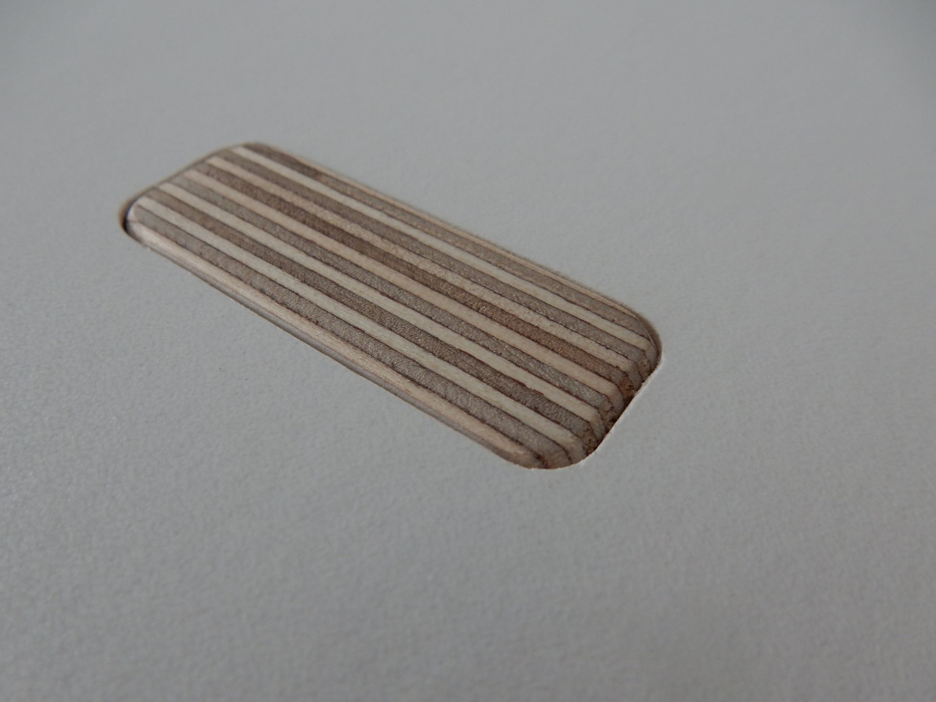 Detailaufnahme: Tojo Rund Tisch, Holzeinsatz mit Streifenmuster in einer Tischplatte.