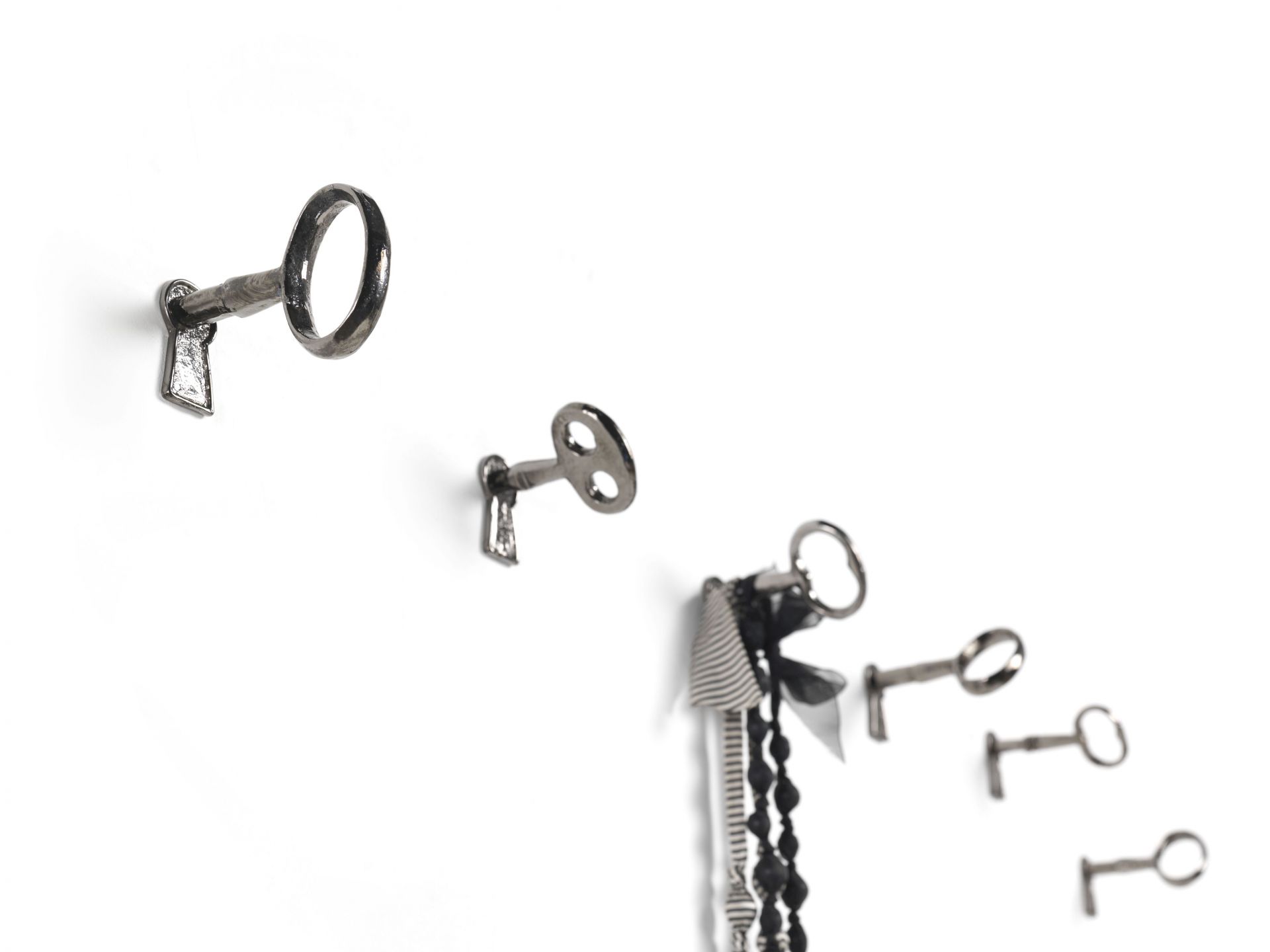 Memorie Wandhaken von Mogg: Vier silberne Schlüssel als Wandhaken, einer mit Dekoration.