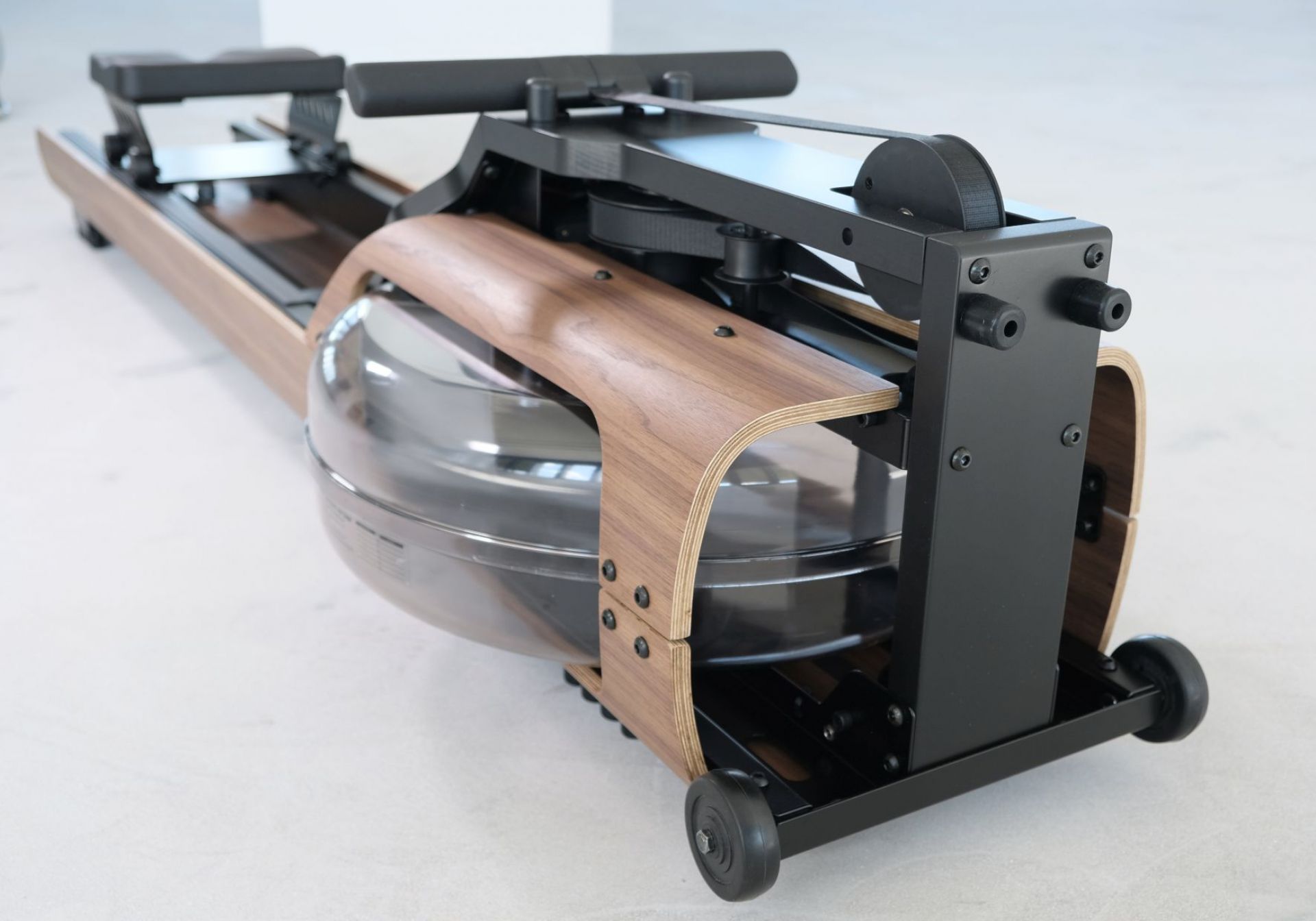FLOW ONE Rudergerät von Stil-Fit: Detailansicht des schwarzen Rudergeräts mit Wassertank und Holzrahmen.