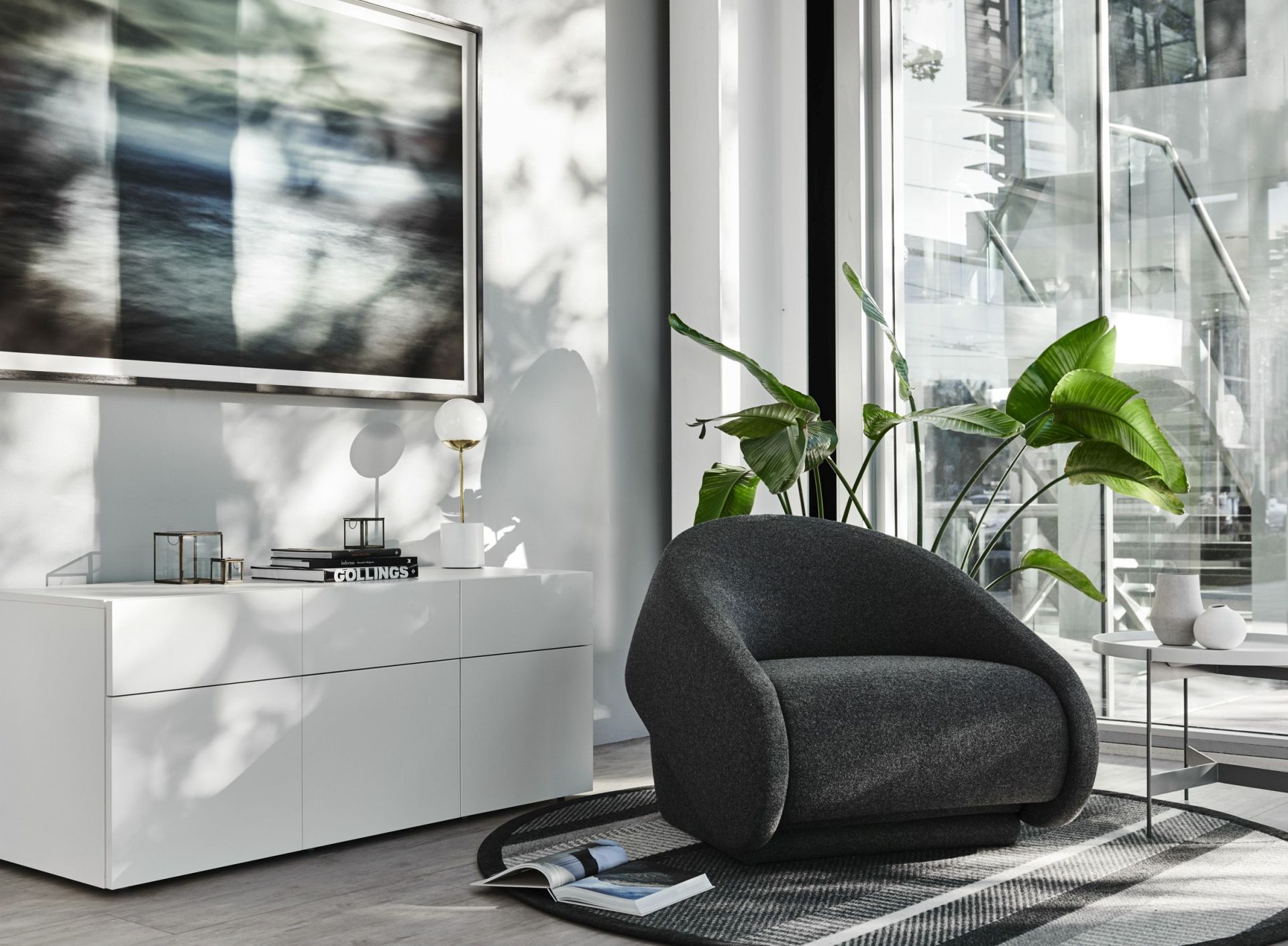 Grauer Up-lift Sessel von Prostoria im modernen Wohnzimmer mit Teppich und weißen Möbeln.