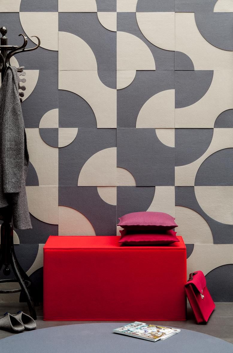 Roter Quader Sitzhocker von Hey Sign mit Kissen vor gemusterter Wand. Filzhocker als Sitzmöbel.