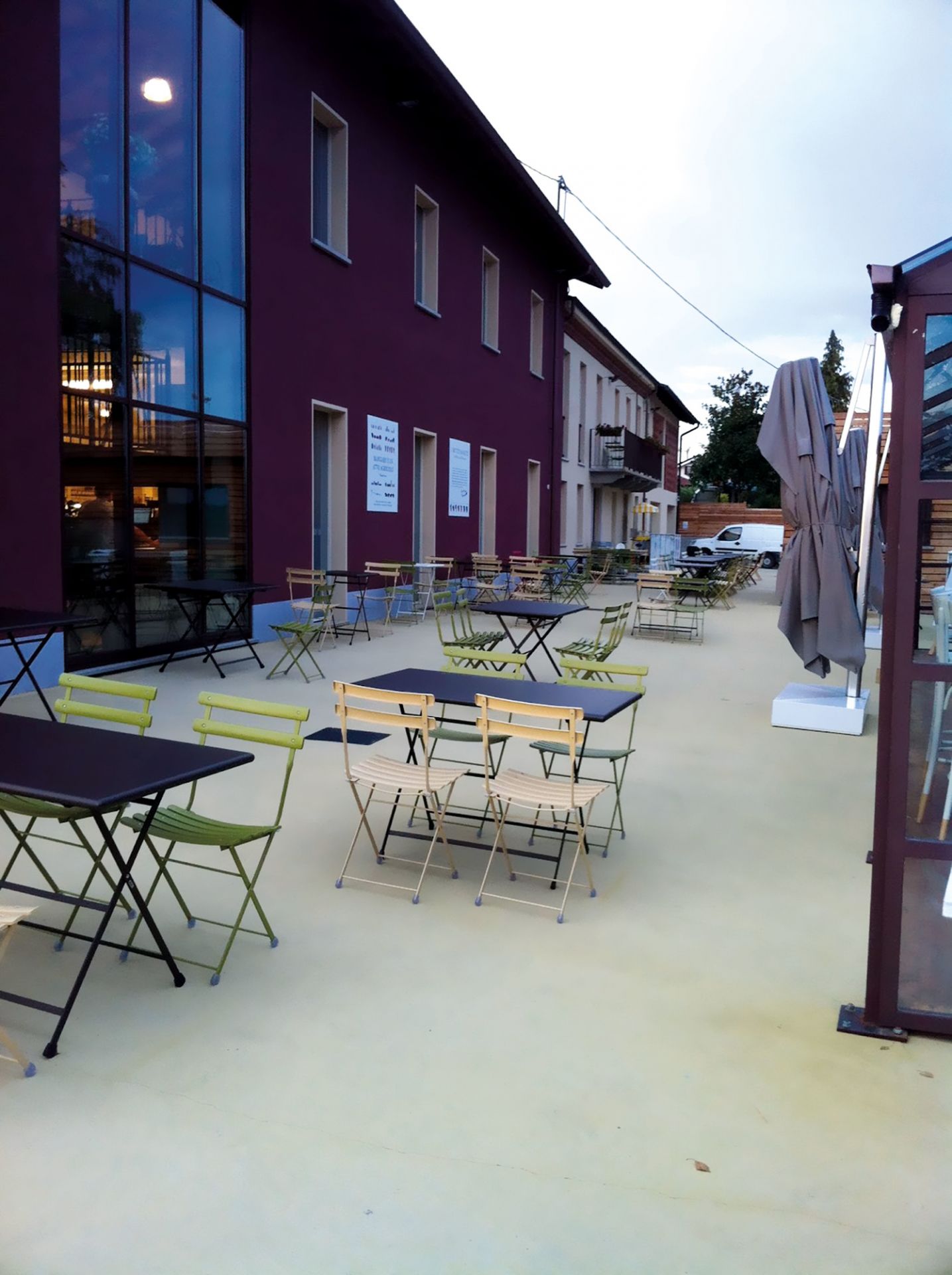 Außenbereich mit mehreren Arc en Ciel Klapptischen und Stühlen von emu, ideal für Gastronomie.