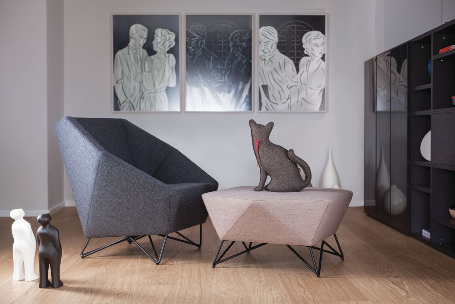 Grauer 3angle Sessel von Prostoria mit passendem Hocker und dekorativer Katzenfigur im Wohnzimmer.