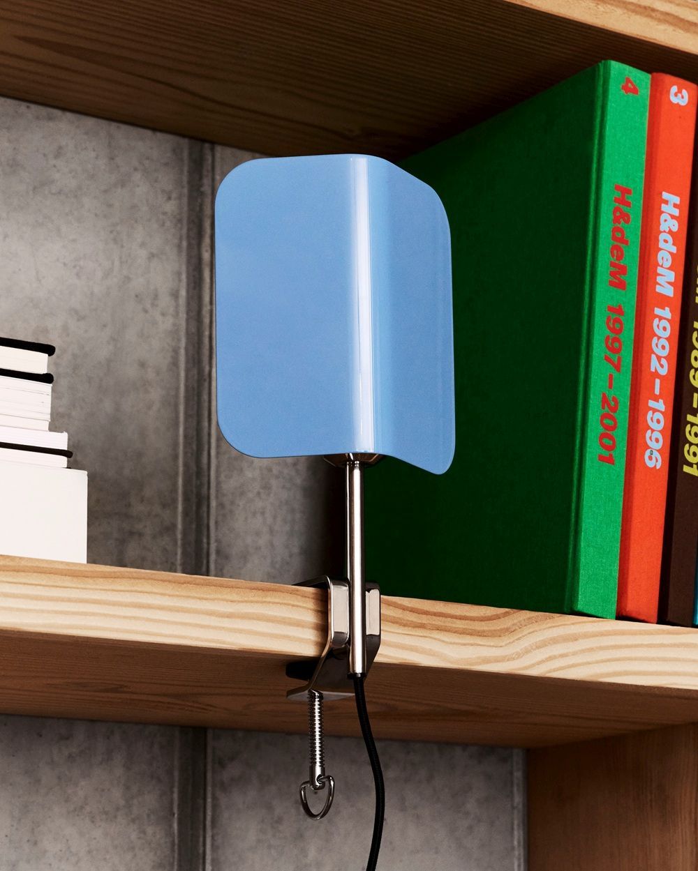 Modernes Büro mit Hay Apex Clip Lamp, Schreibtisch, Stühlen und Bücherregal in minimalistischem Design.