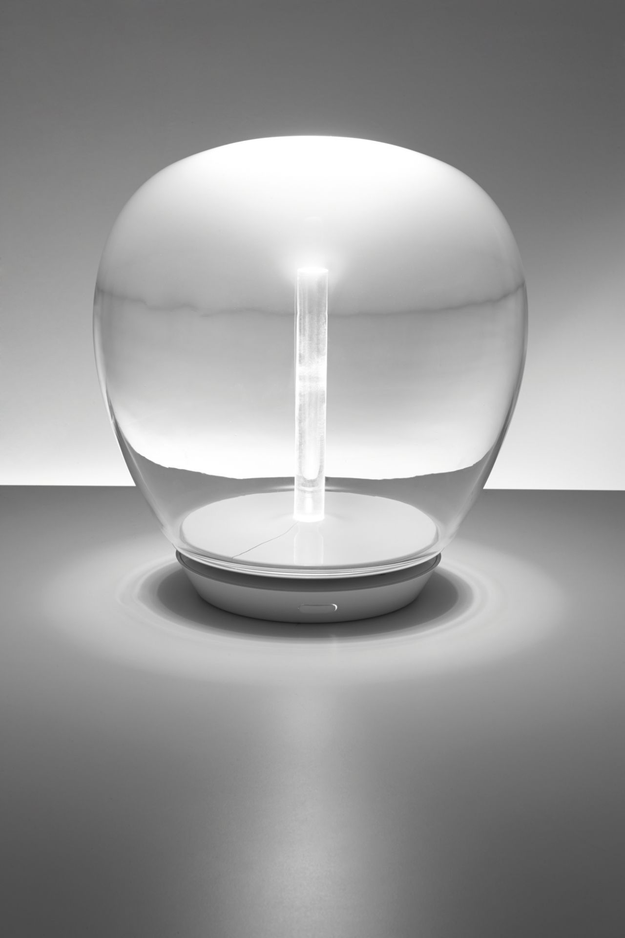 Empatia Tischleuchte von Artemide: Moderne Lampe mit Glaskörper und zentralem Lichtelement.