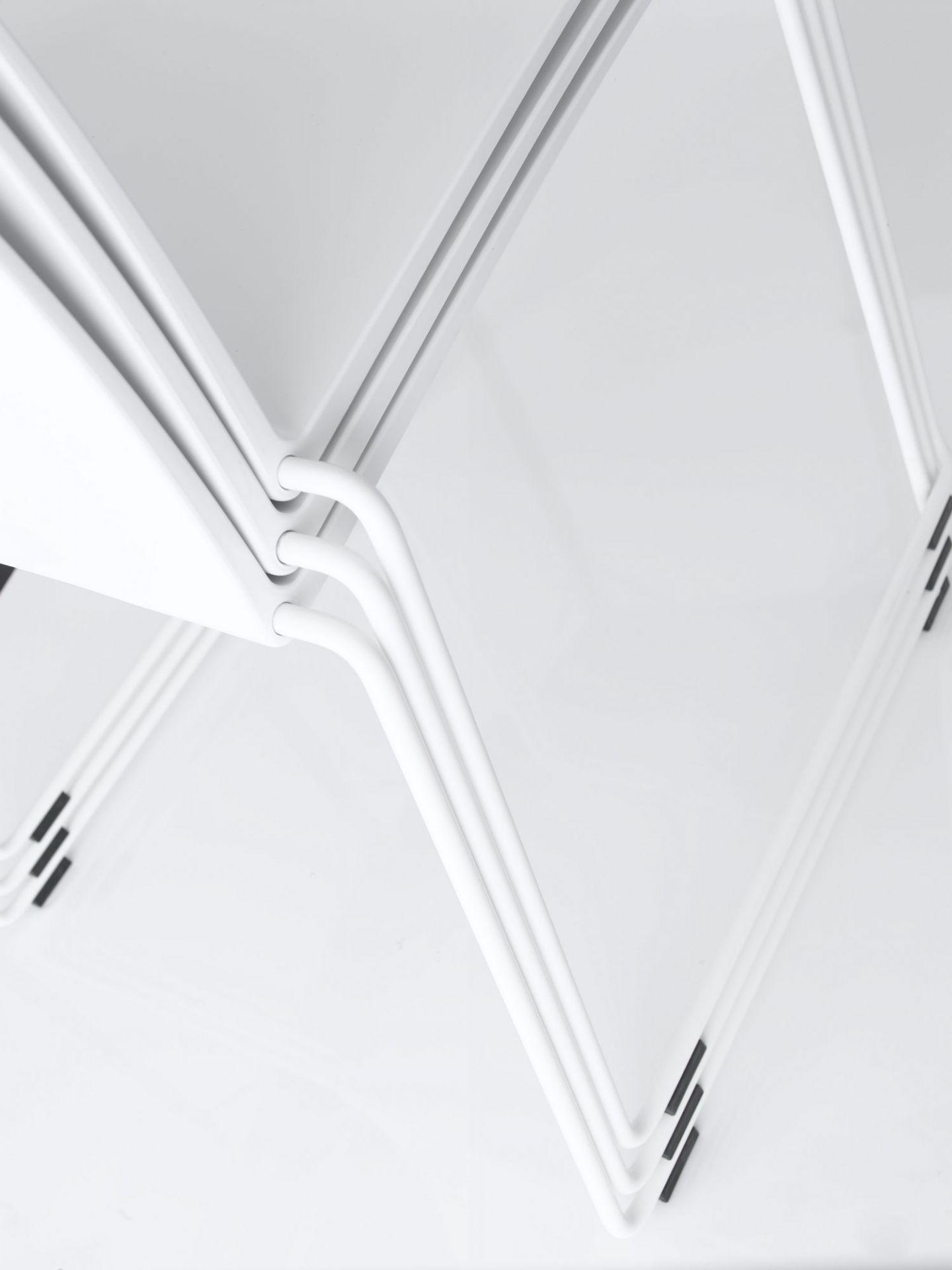 Detailaufnahme von gestapelten, weißen M1 Stühlen von MDF Italia. Minimalistisches Design.