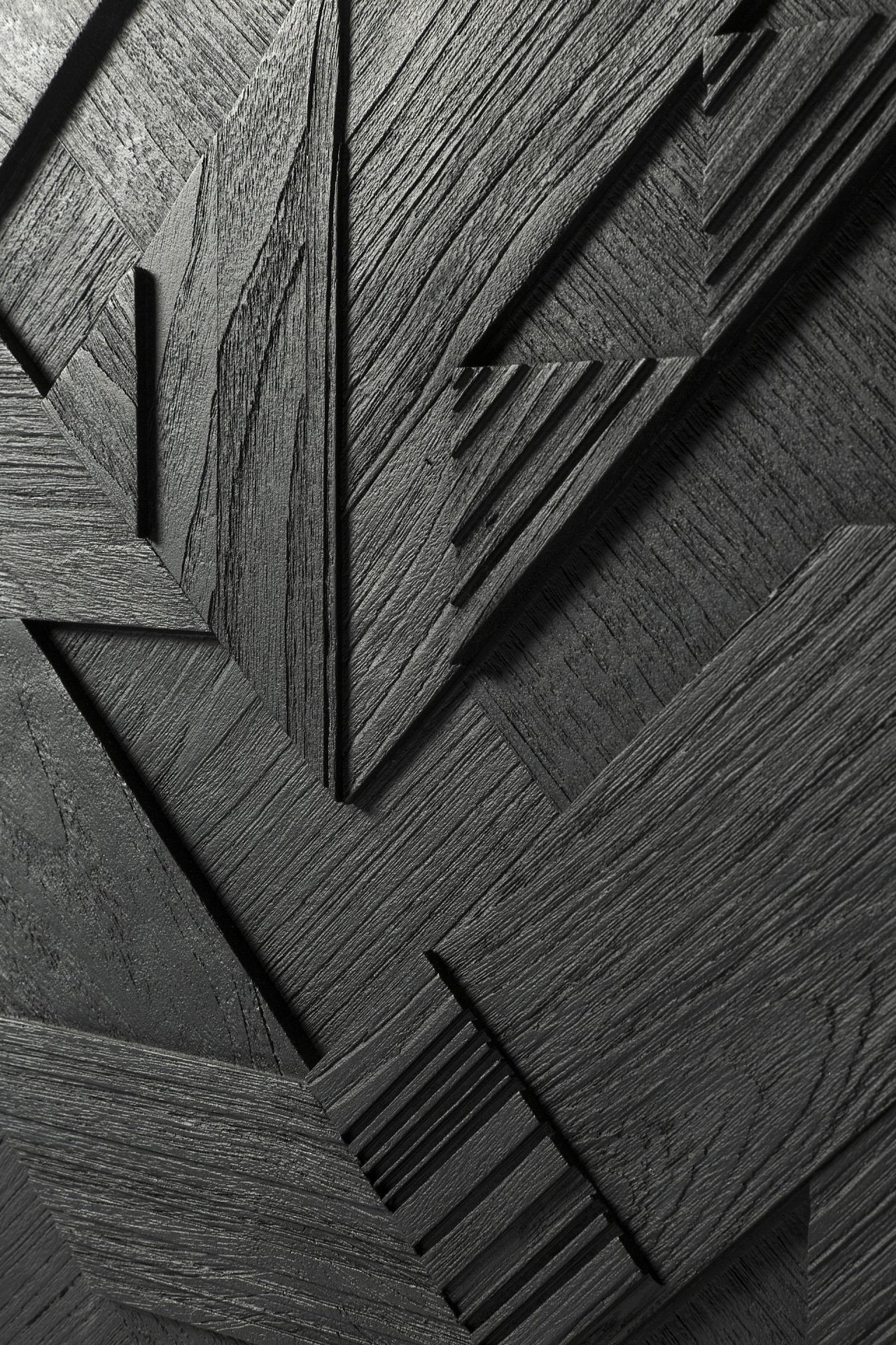 Detailaufnahme der schwarzen Graphic Teak Anrichte von Ethnicraft mit geometrischem Muster und Holzmaserung.