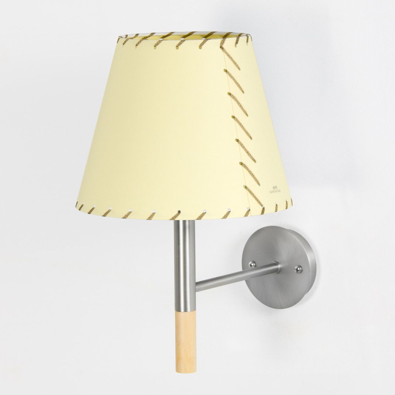 BC2 Wandleuchte von Santa & Cole mit gelbem Lampenschirm und Metallhalterung an der Wand.