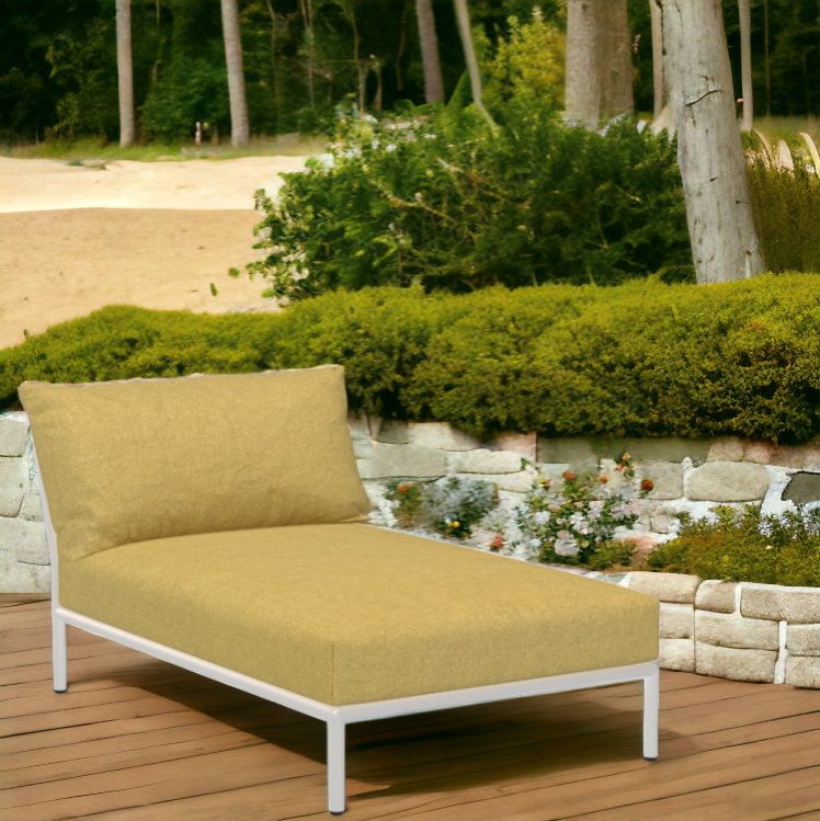 Houe Level 2 Chaiselongue: Outdoor Sessel mit gelbem Bezug und weißem Gestell im Garten.
