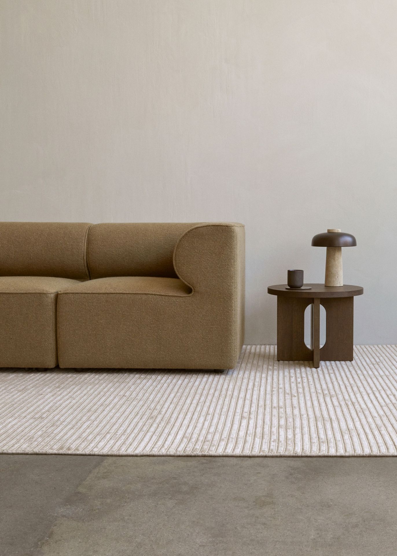 Androgyne Beistelltisch von Audo mit dunklem Eichengestell neben einem beigen Sofa auf einem Teppich.