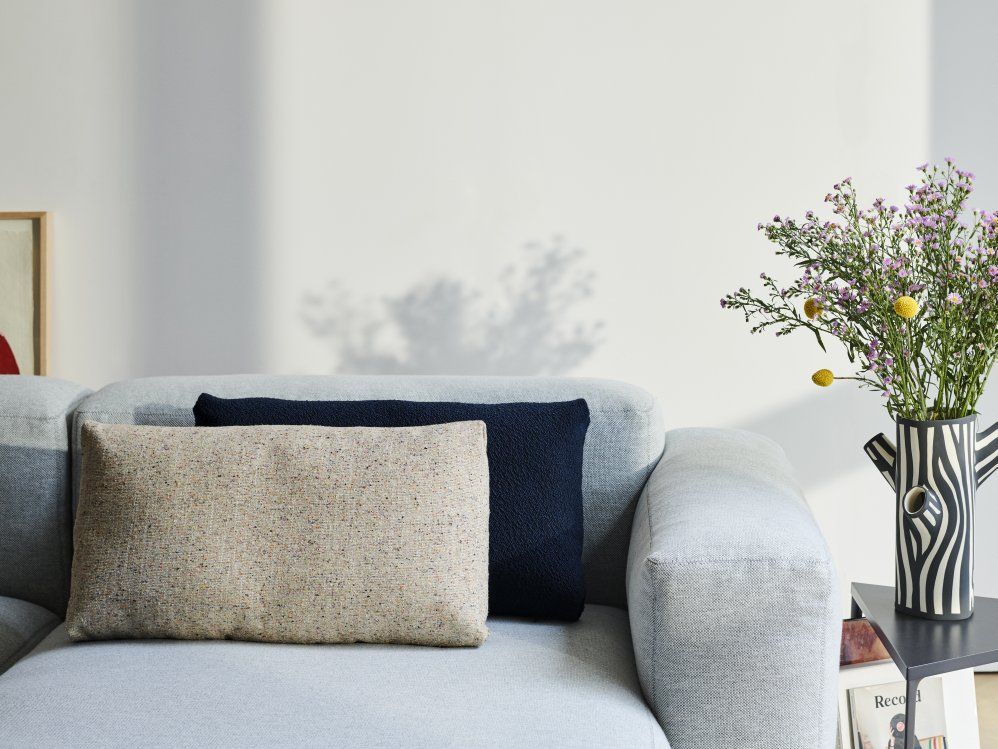 Nahaufnahme: Mags Soft Sofa mit beigen Kissen und Armlehne. Gemütliches Wohnzimmer-Ambiente.