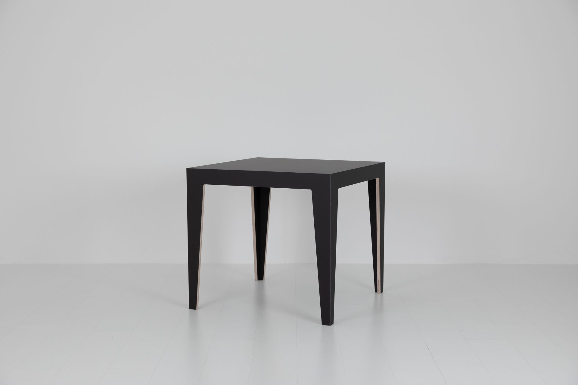 Schwarzer MARTA Holztisch mit minimalistischem Design und vier Beinen auf weißem Hintergrund.