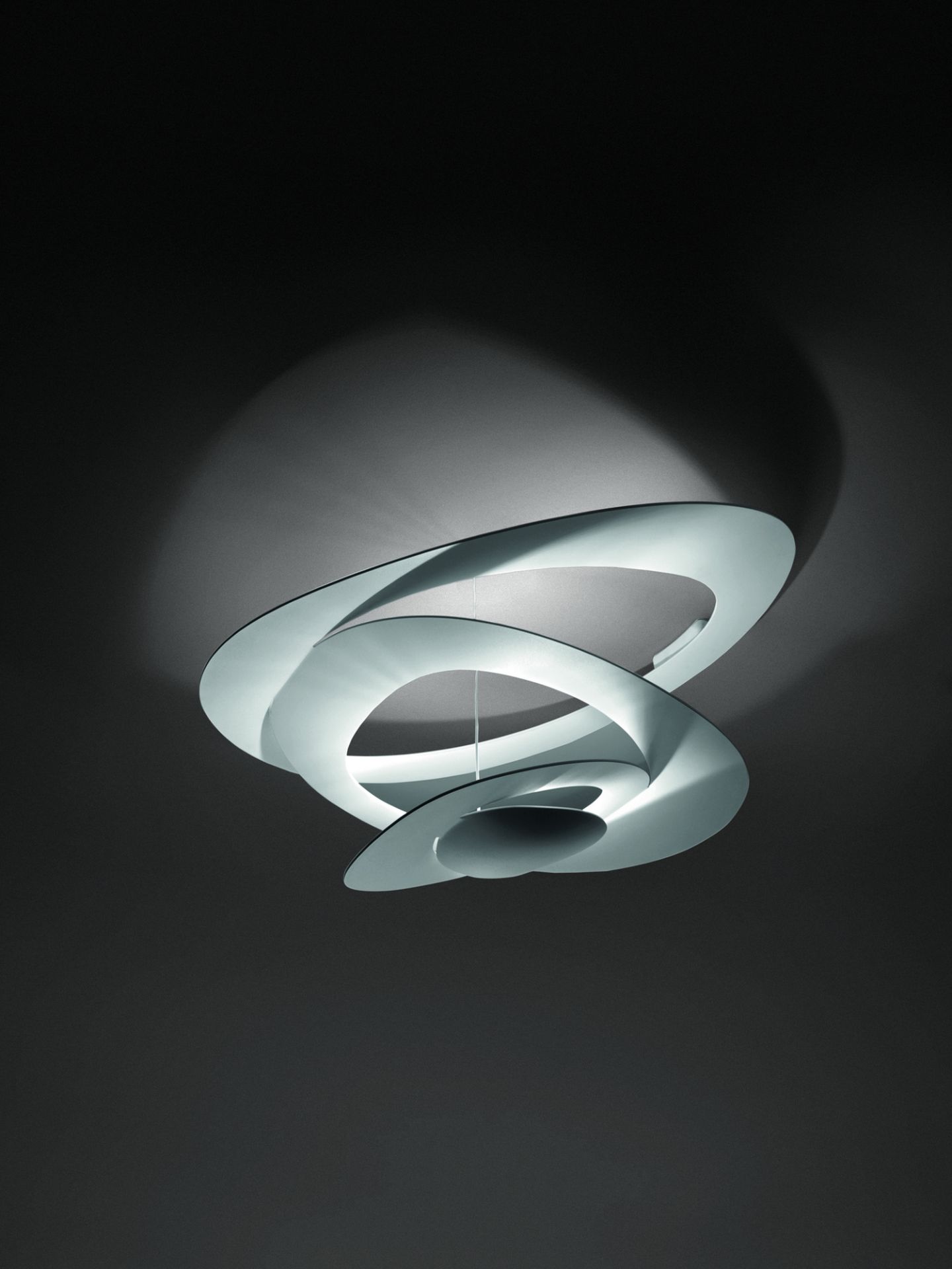 Weiße Pirce Deckenleuchte von Artemide: Moderne Deckenlampe mit spiralförmigen Elementen und indirekter Beleuchtung.