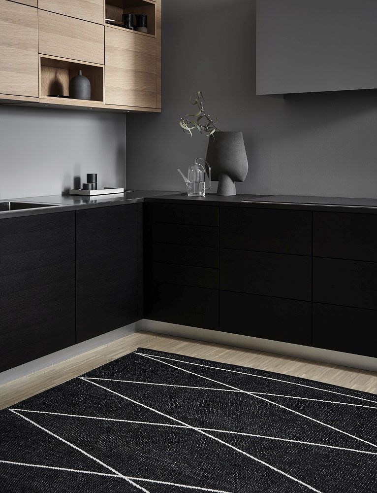Schwarzer Kunststoffteppich mit weißem Muster in moderner Küche. Pappelina Teppich, Modell Max, 70x100 cm.