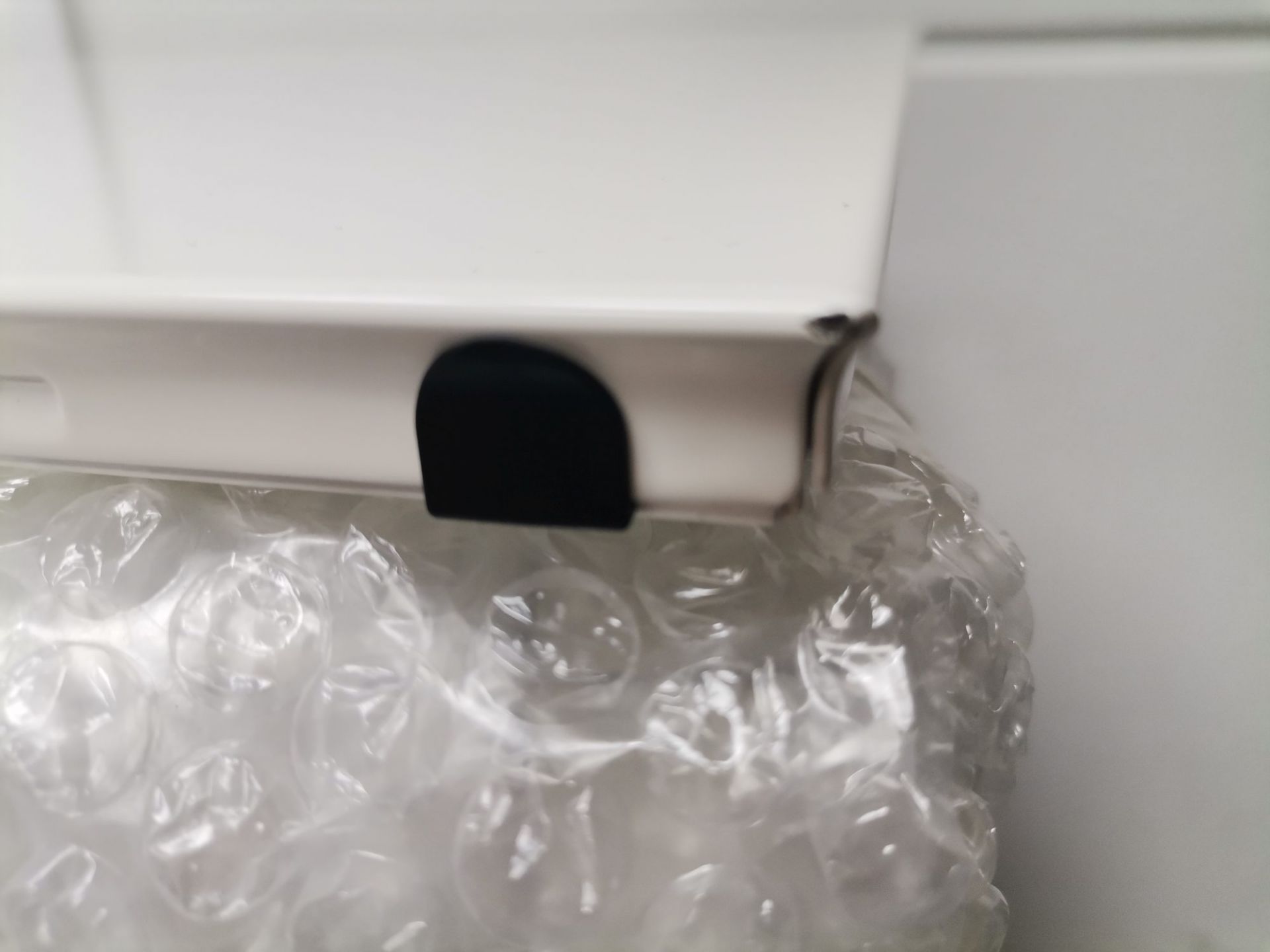 Detailaufnahme von verpackten USM Haller Ersatzteilen, Mängelexemplar mit Luftpolsterfolie und weißem Karton.