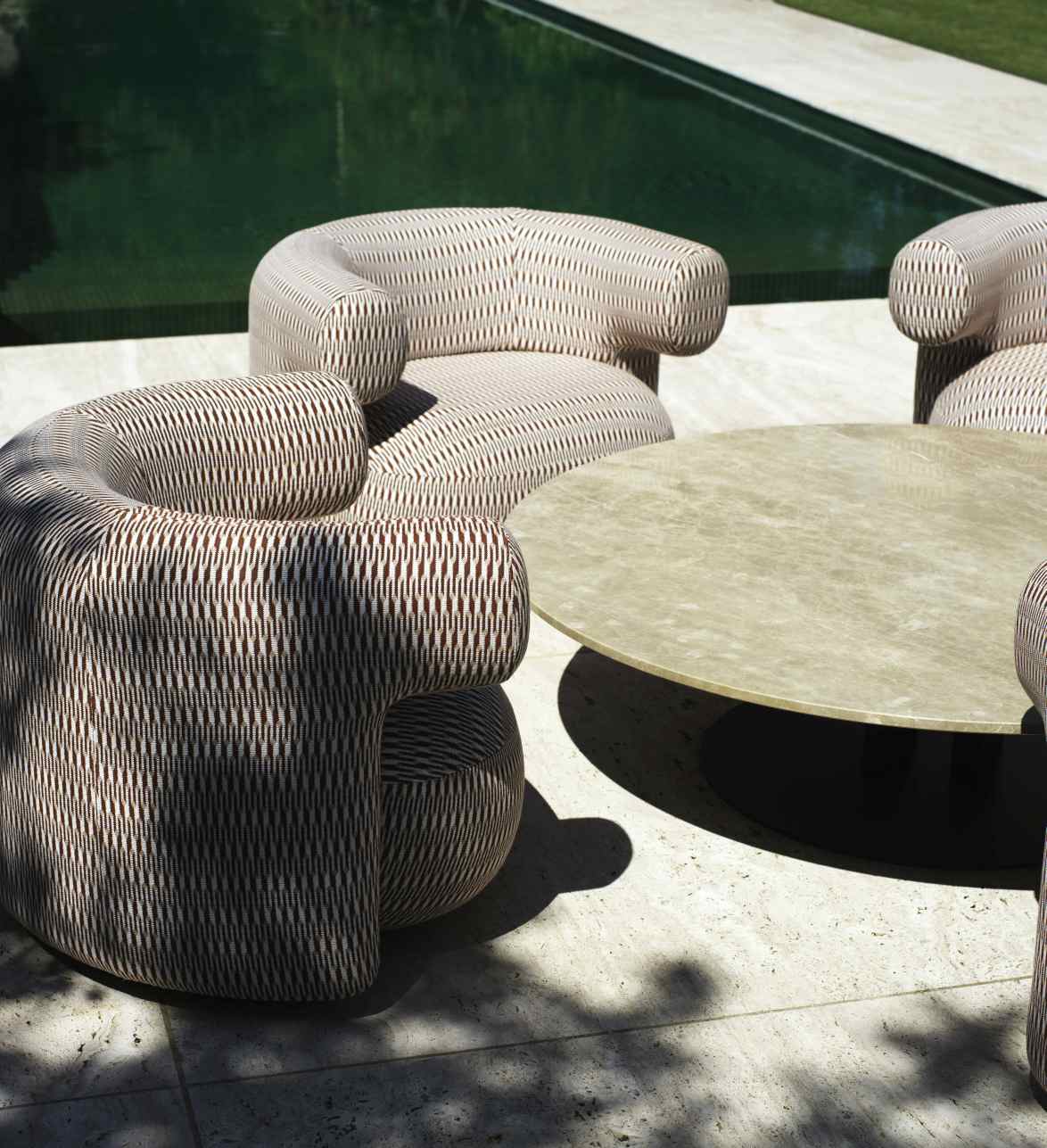 Burra Lounge Chair von Normann Copenhagen im Außenbereich mit Tisch und Pool.