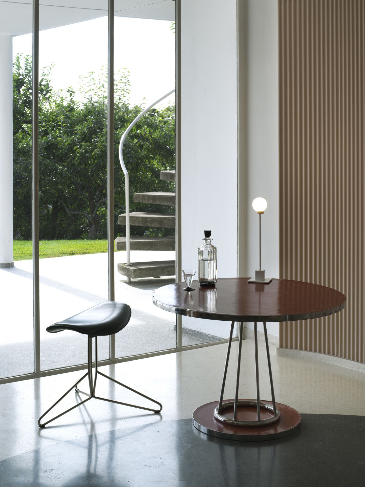 Snowball Table LED Tischleuchte Northern Weiß auf rundem Tisch mit Dekanter und Glas.