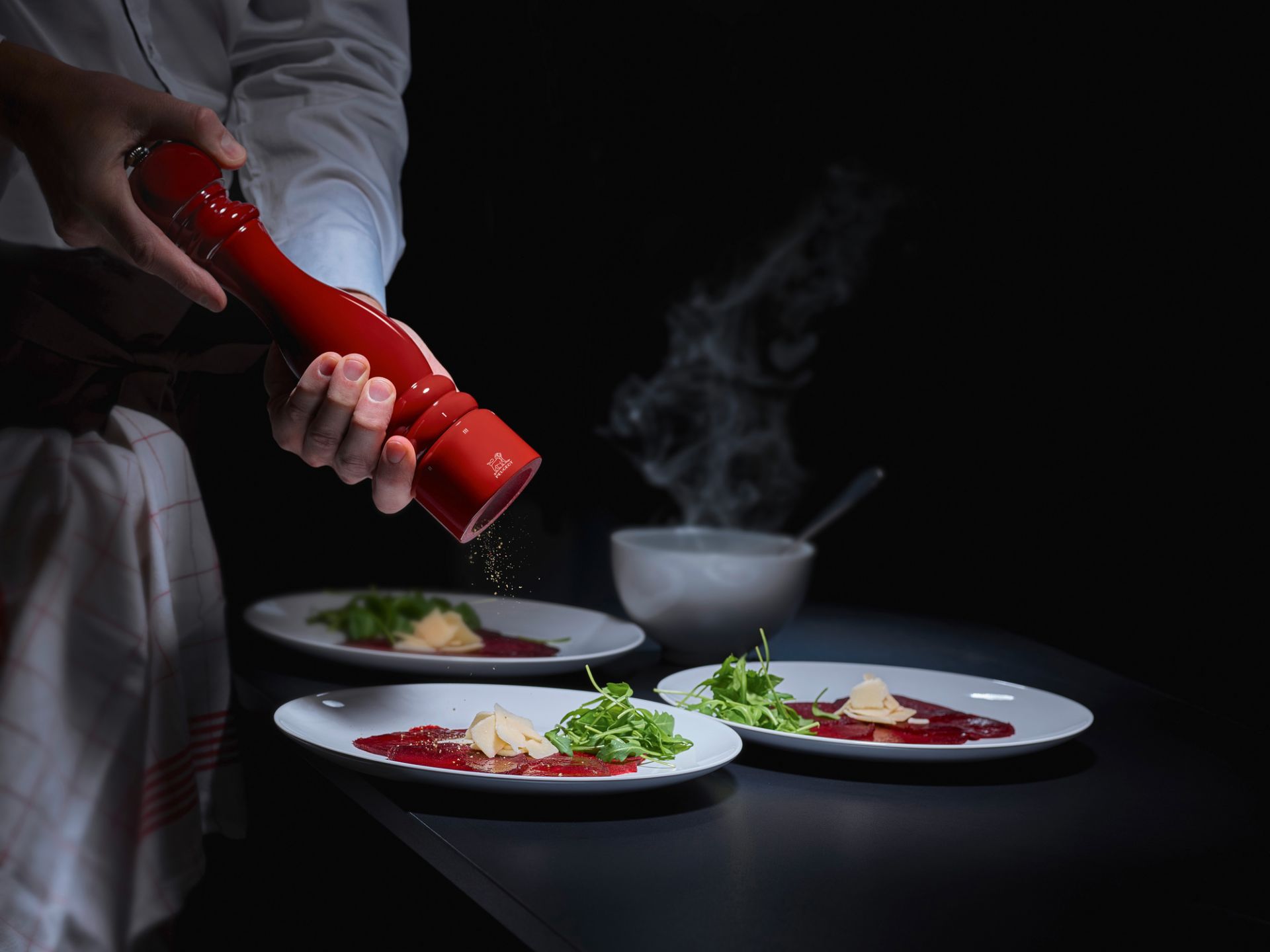 Rote Peugeot Pfeffermühle Paris, 30cm, würzt Carpaccio auf Tellern. Hochwertige Mühle für Feinschmecker.