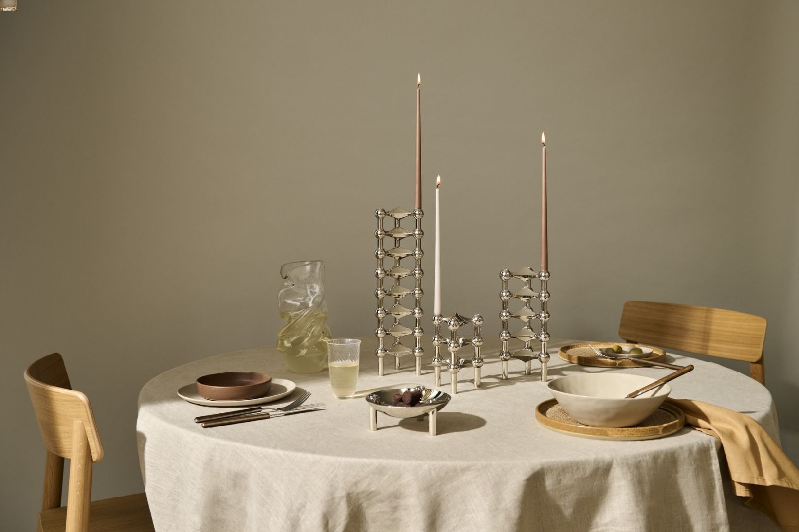 Tischdekoration mit Chrom Kerzenständer 3er Set, Stoff-Tischdecke und passendem Geschirr.