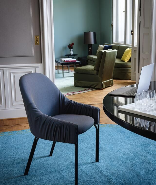 Blauer Celine Armchair Low Sessel von Freifrau Manufaktur mit gerafften Armlehnen und schwarzen Beinen.
