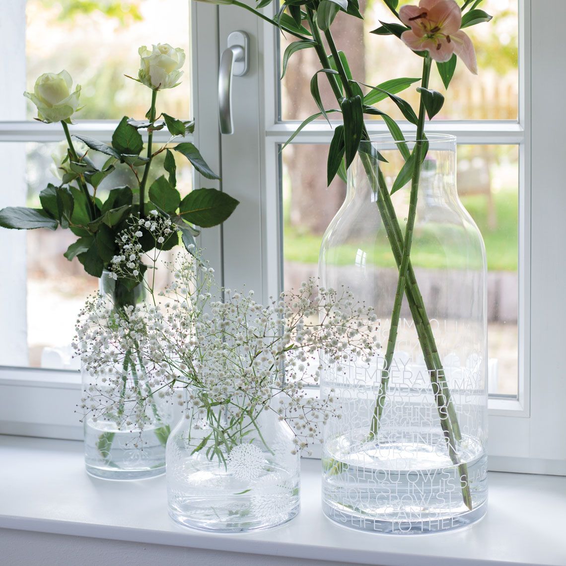Drei Living Glasvasen mit Blumen auf einer Fensterbank, dekorative Blumenvase für Zuhause.