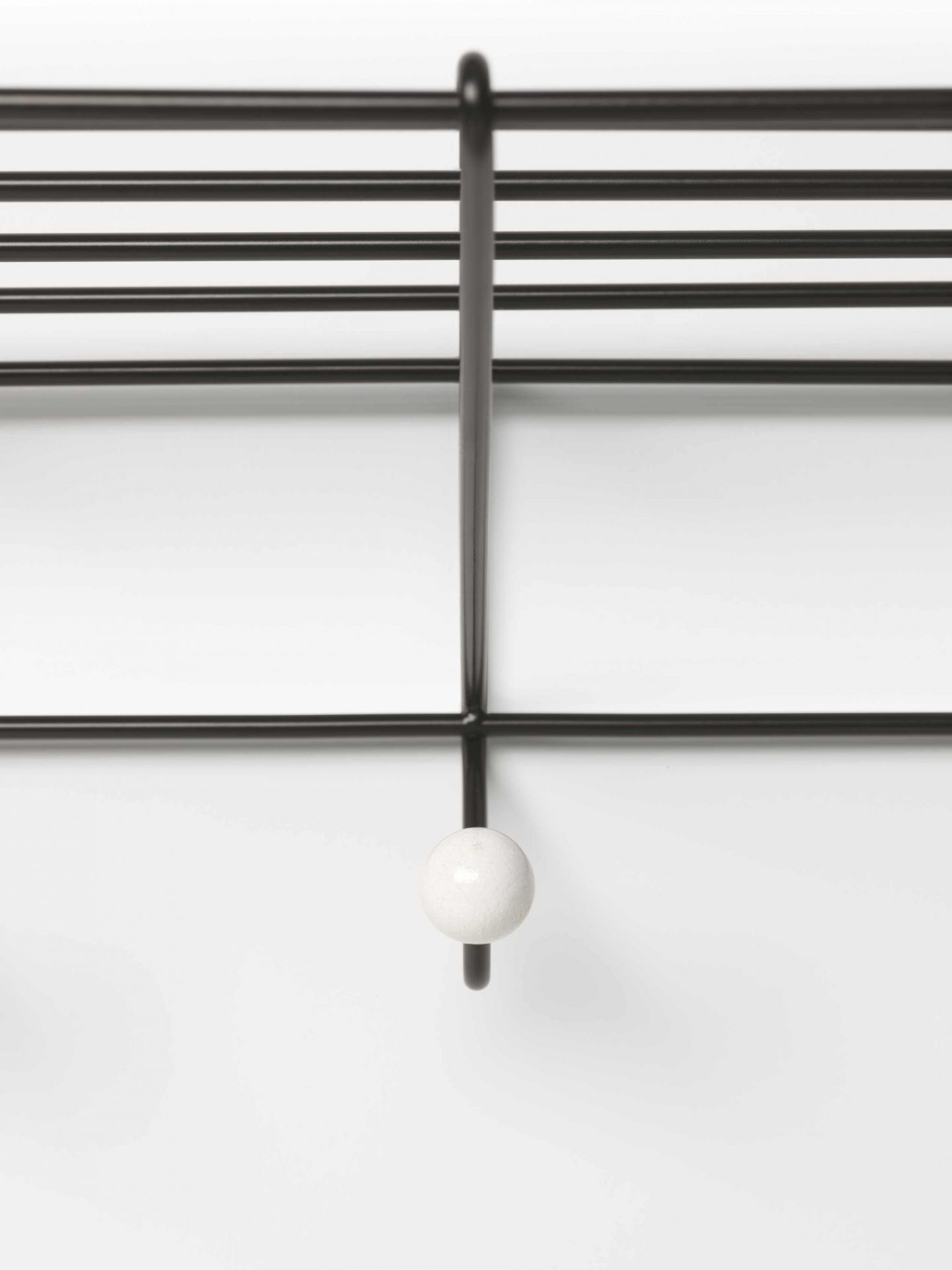 Detailaufnahme der DZ 05 Garderobe Spectrum: Schwarzes Metallgestell mit weißem Knauf. Moderne Wandgarderobe.