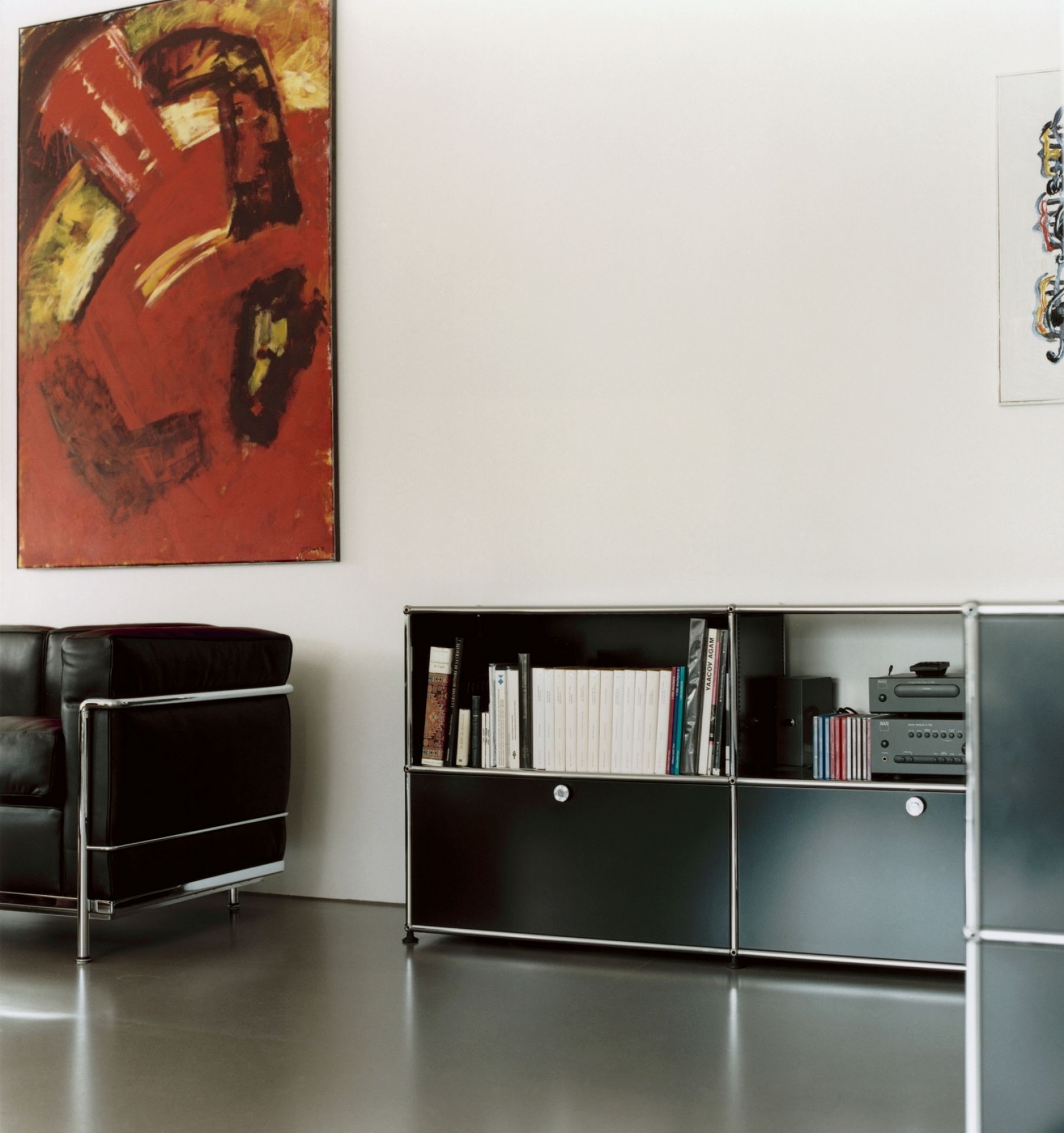 Nahaufnahme eines schwarzen USM Haller Sideboards mit Schubladen und Büchern im Wohnzimmer.