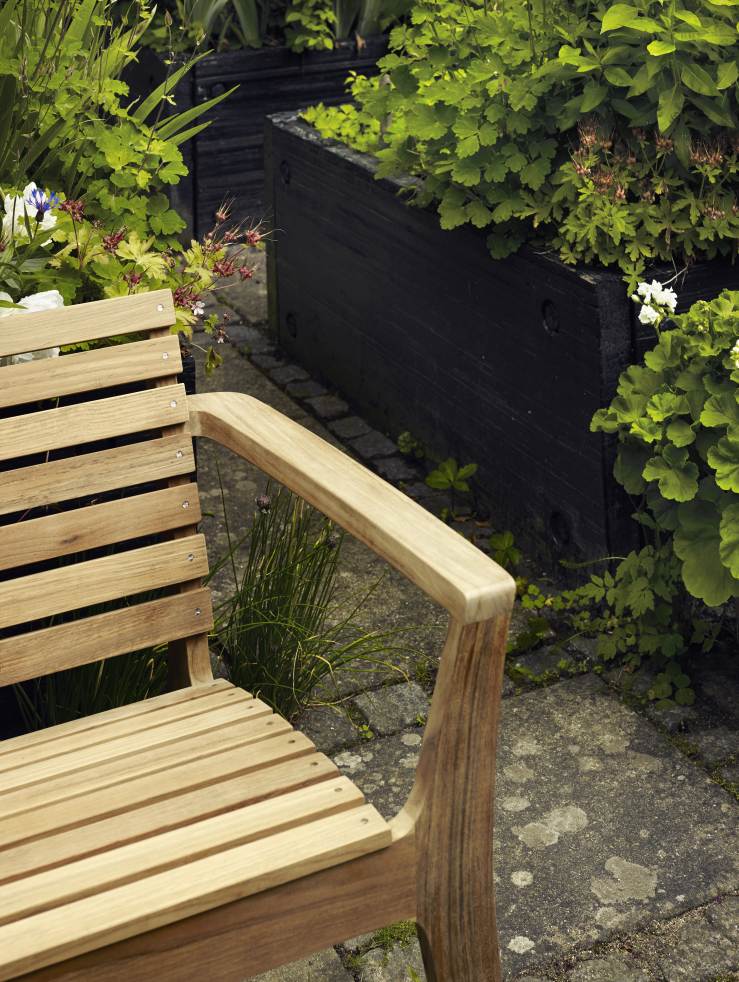Detailaufnahme des Regatta Chair Stuhls von Skagerak by Fritz Hansen im Garten. Holzstuhl für den Außenbereich.
